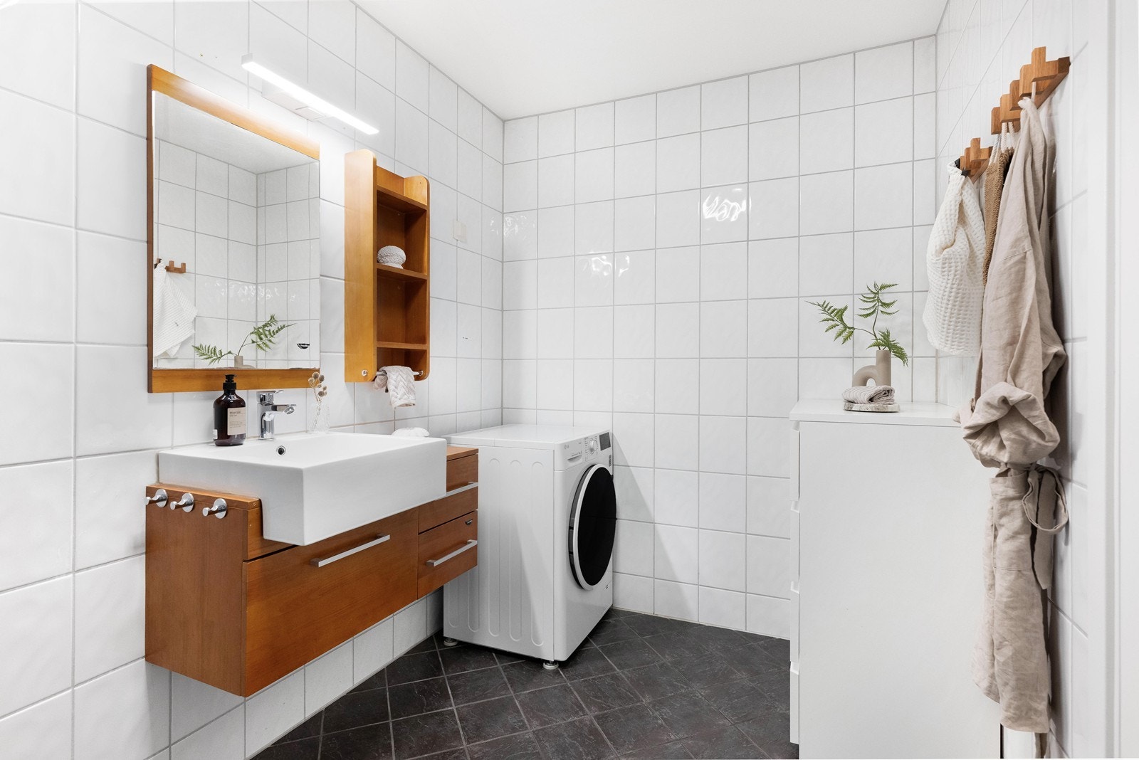 Badet er innredet med servant, toalett, dusj og opplegg for vaskemaskin. Galleribilde