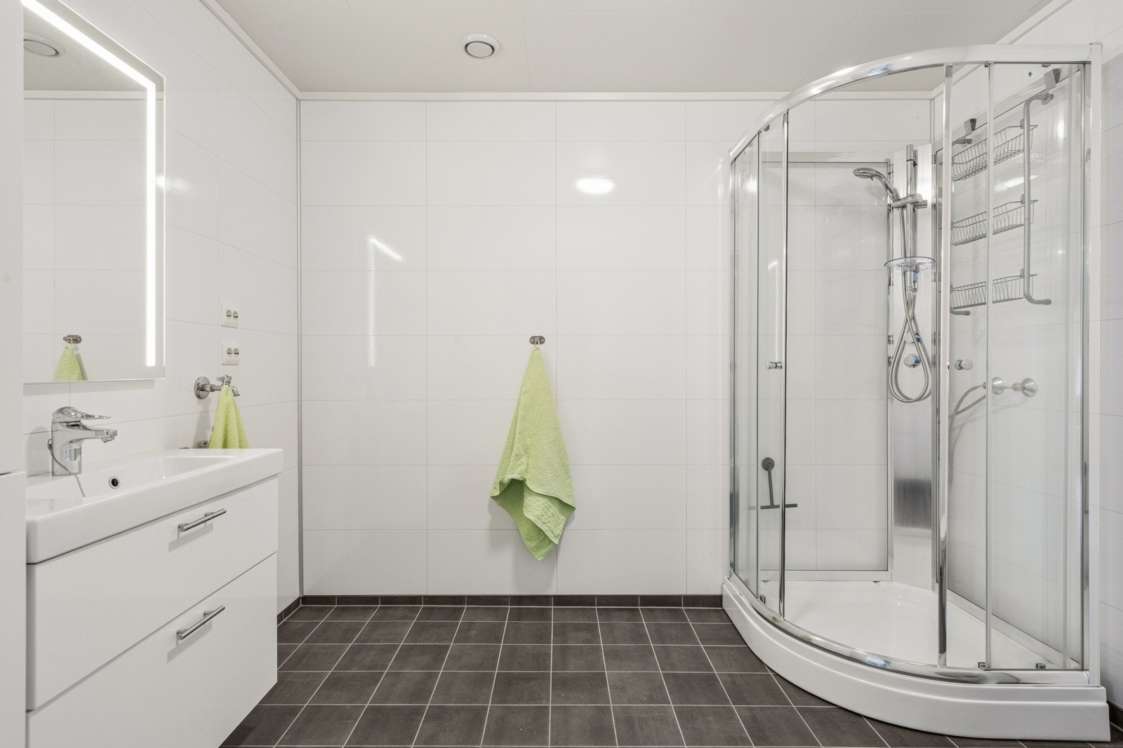 Pent bad/wc/vaskerom med flislagt gulv, gulvvarme og opplegg for vaskemaskin.