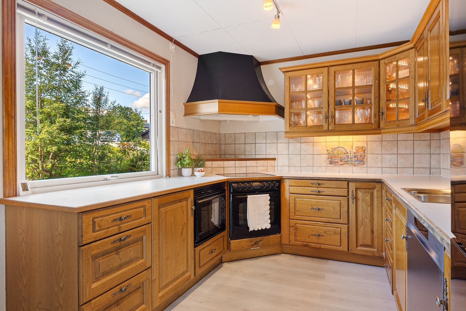 Kjøkkenet er utstyrt med skrog med profilerte fronter i tre og enkelte med glassfelt, samt laminert benkeplate. Galleribilde