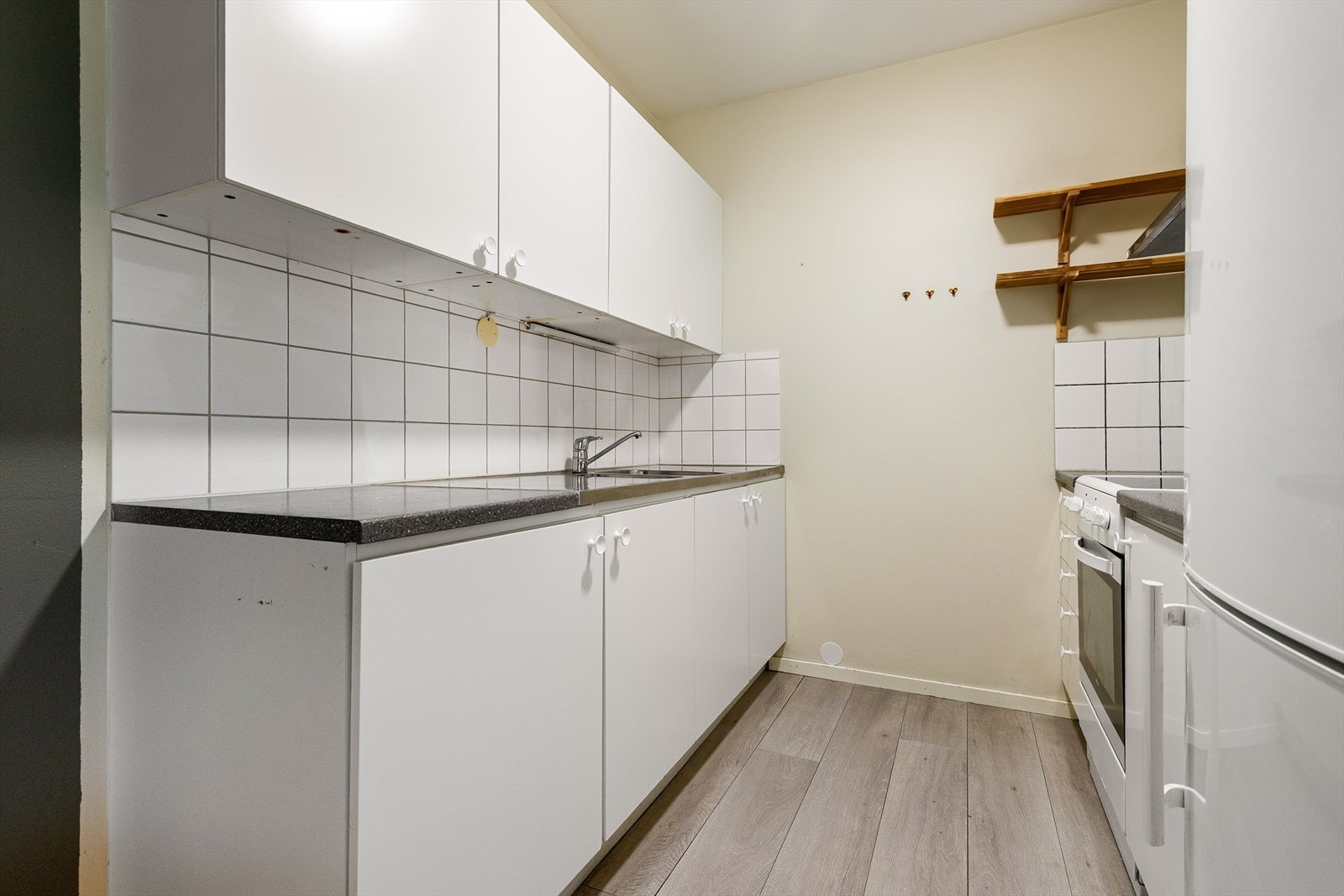Kjøkkenet har glatte fronter og benkeplate i laminat med beslag i rustfritt stål og dobbel oppvaskkum med svingbart blandebatteri. Galleribilde