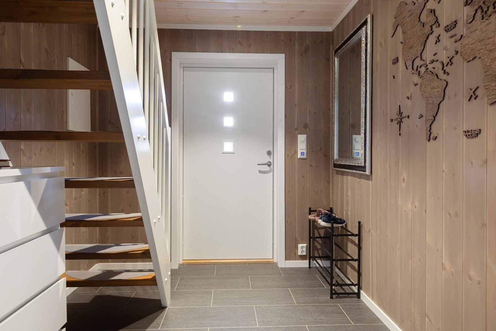 I den romslige entréen, som har praktisk gulv med fliser og varmekabler, er det god plass til ytterjakker og sko. Galleribilde