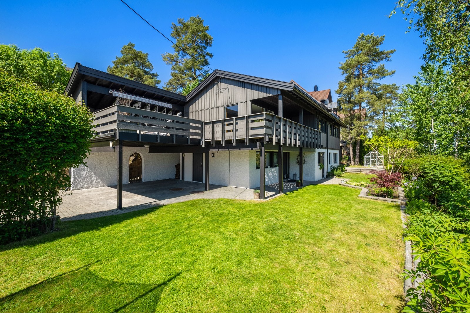 Stor tomt på hele 888 kvm med en pent opparbeidet hage med plen, beplanting, heller og drivhus Galleribilde