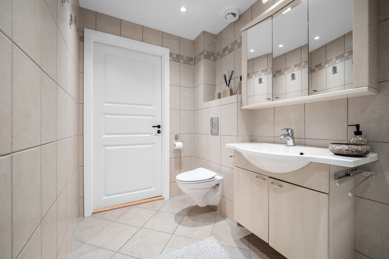 Rommet har innredning med nedfelt servant, veggmontert toalett og dusjkabinett Galleribilde