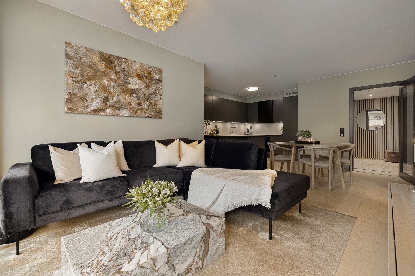 Den åpne løsningen mot kjøkkenet skaper en romslig og sosial sone, perfekt for både hverdagsliv og gjester. Galleribilde