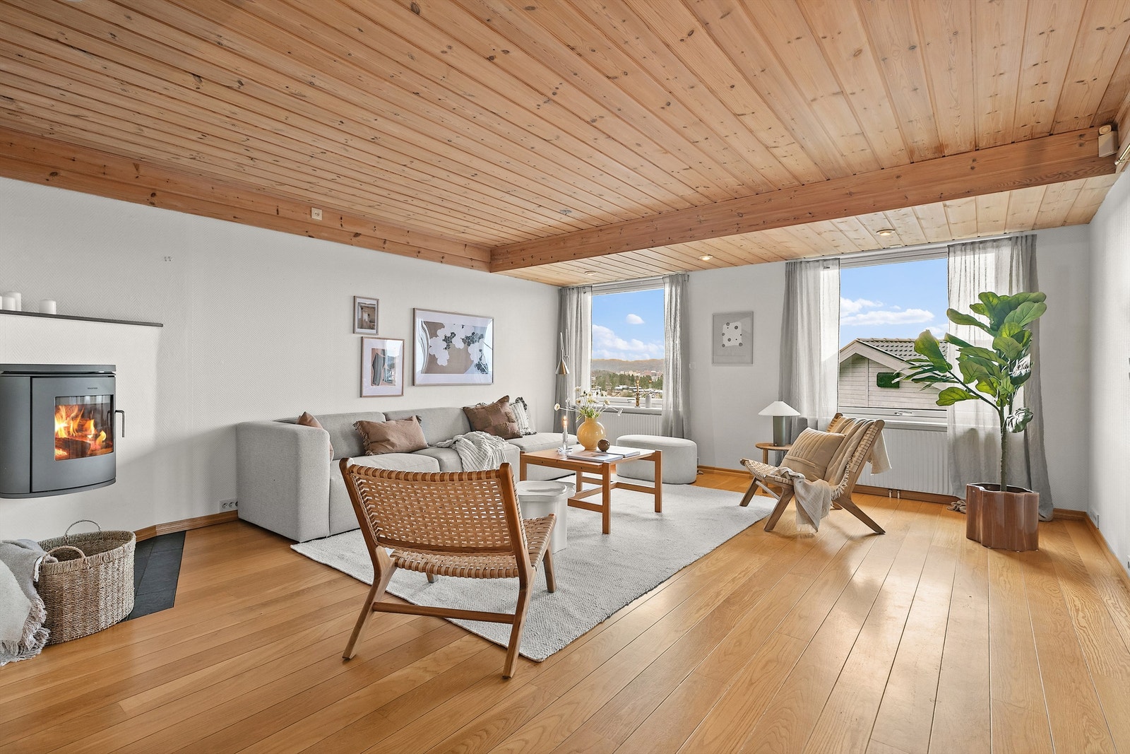 Stuen er lys og stor med parkett på gulvet. Store vinduer slipper inn mye lys. Galleribilde