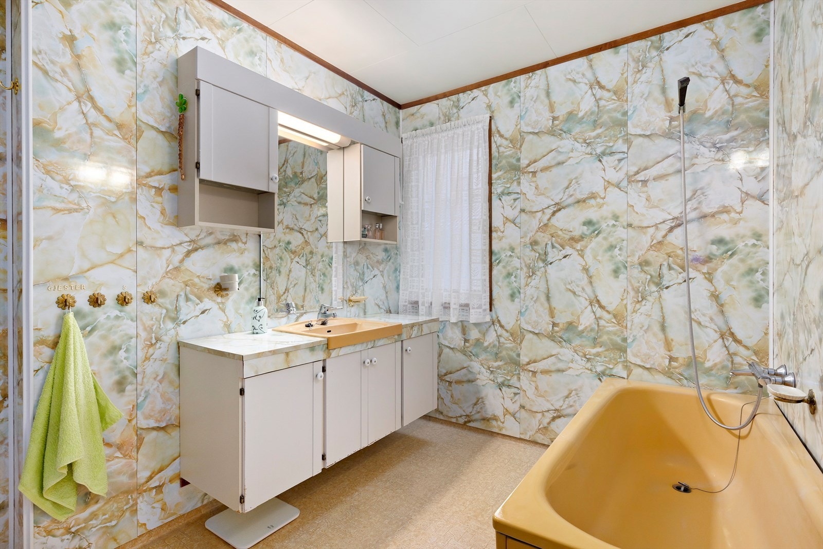 Overflater består av vinylbelegg på gulv og baderomsplater på vegger. Badet har behov for full rehabilitering. Galleribilde