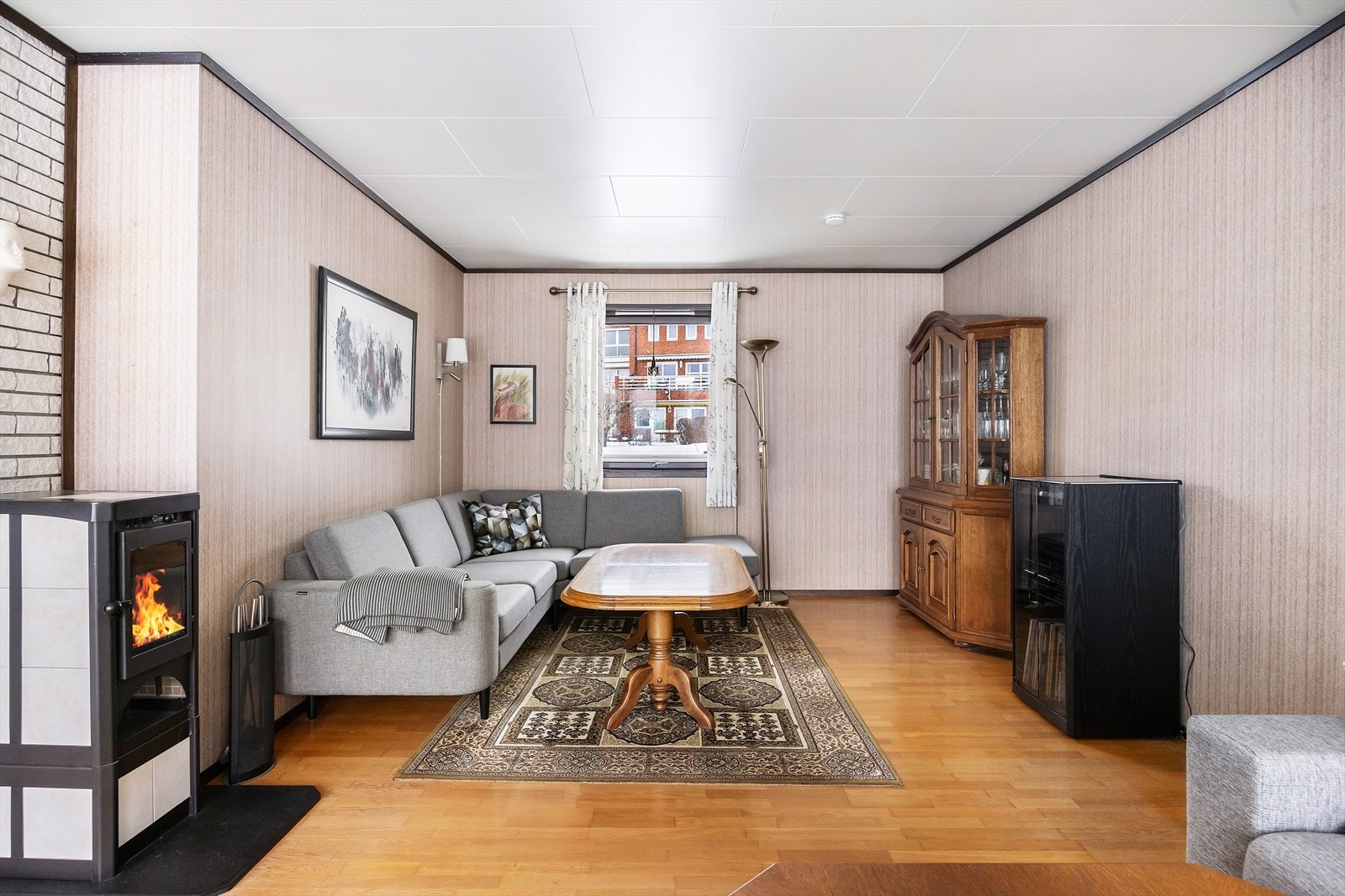 Stuen er utstyrt med vedovn plassert på ildfast plate, som bidrar til ekstra varme og en hyggelig atmosfære i rommet. Galleribilde
