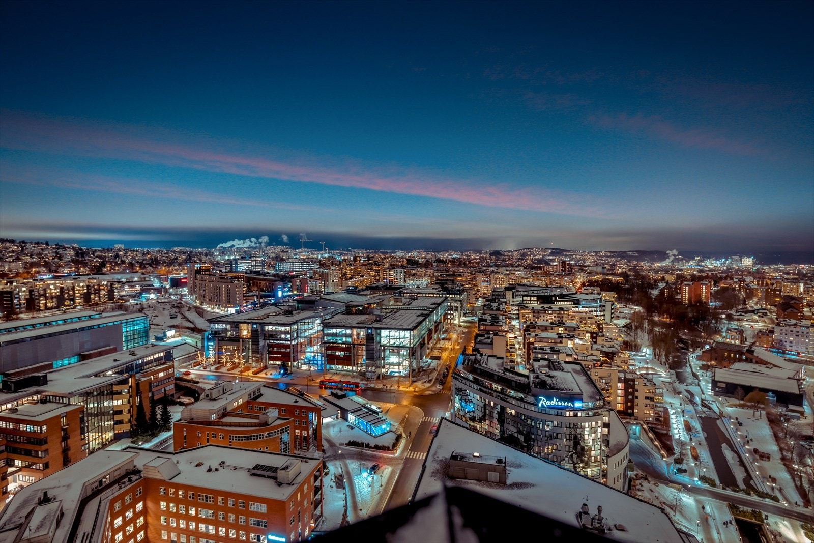Utsikten er spektakulær, med panoramablikk over byen og fjorden, hvor lysene fra bebyggelsen skaper et levende og imponerende skue på kveldstid. Galleribilde