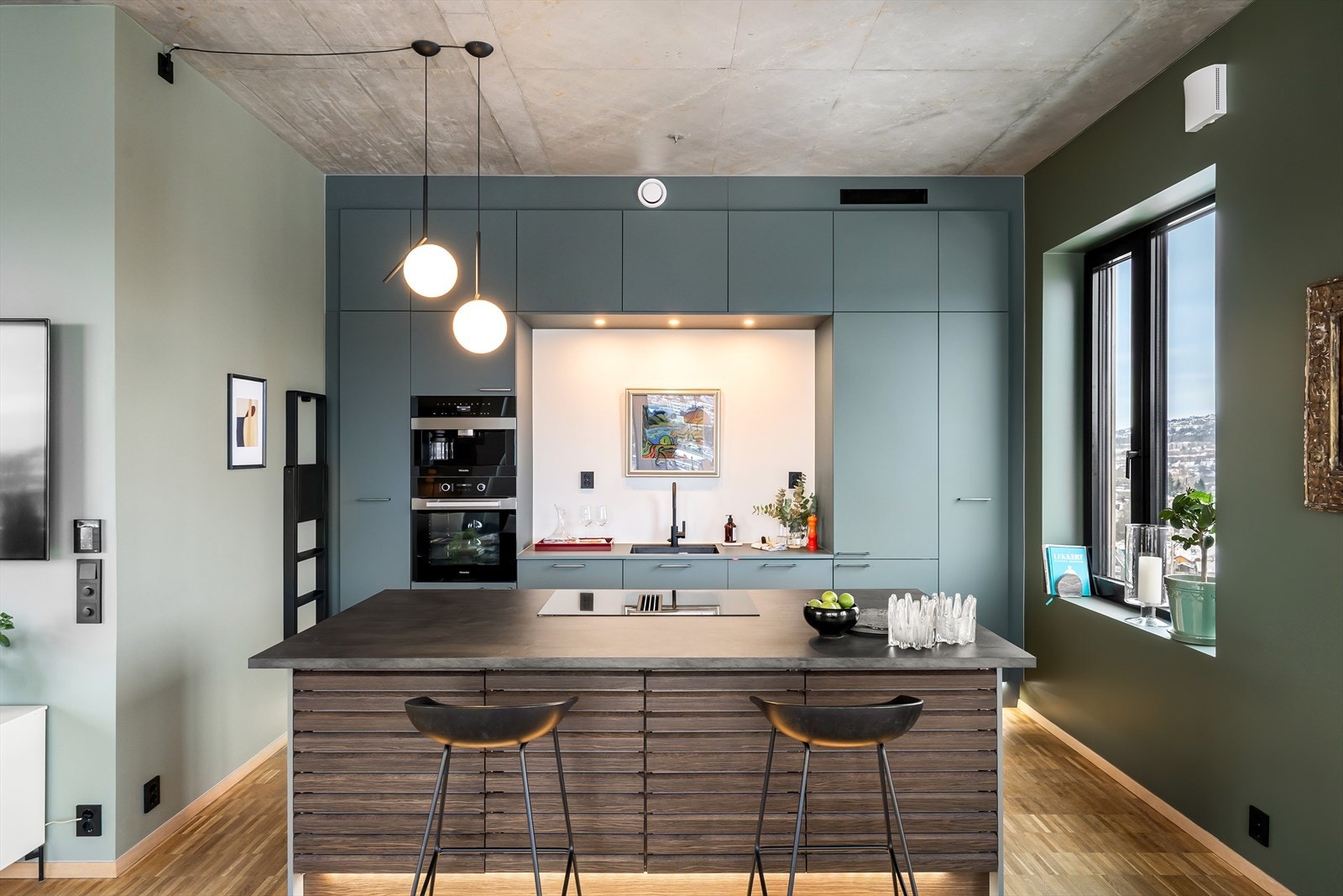 Kjøkkenet har glatte fronter og god skap- og benkeplass, samt en praktisk kjøkkenøy som gir ekstra arbeidsflate og fungerer godt som sosial sone. Galleribilde