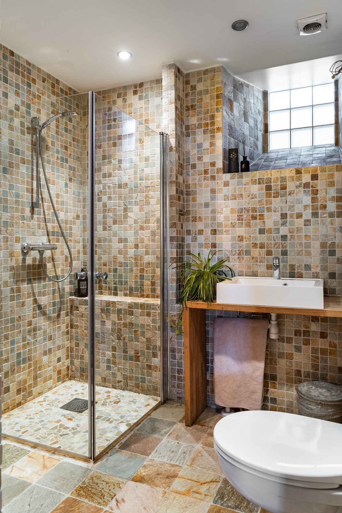 Flislagt bad fra2009 med dusjhjørne, servant i heltre og praktisk nisje med opplegg for vaskesøyle. Galleribilde