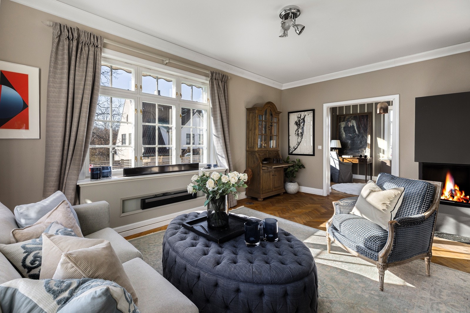 Hovedstuen har store vindusflater på to sider, lysbeige vegger og åpen løsning mot stuen i midten. Galleribilde