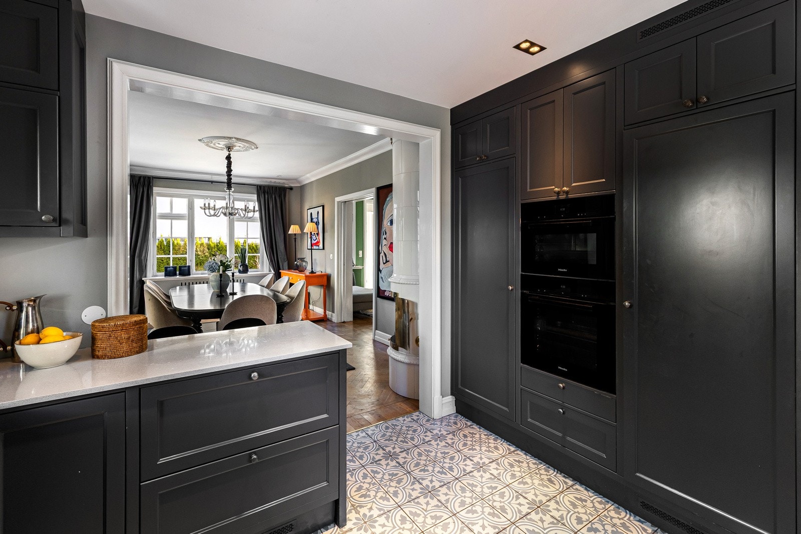 Kjøkkenet har innredning i klassisk stil med sorte, profilerte fronter, og rikelig med skapplass Galleribilde