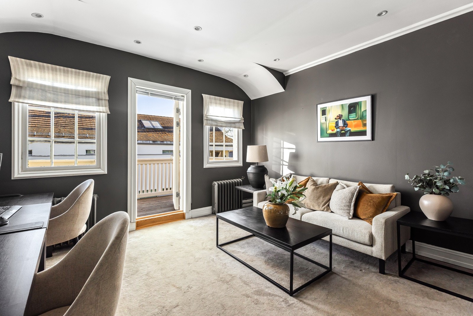 Stuen i andre etasje er luftig og flott med buet tak mot vinduene, downlights og lunt gulvteppe. Galleribilde