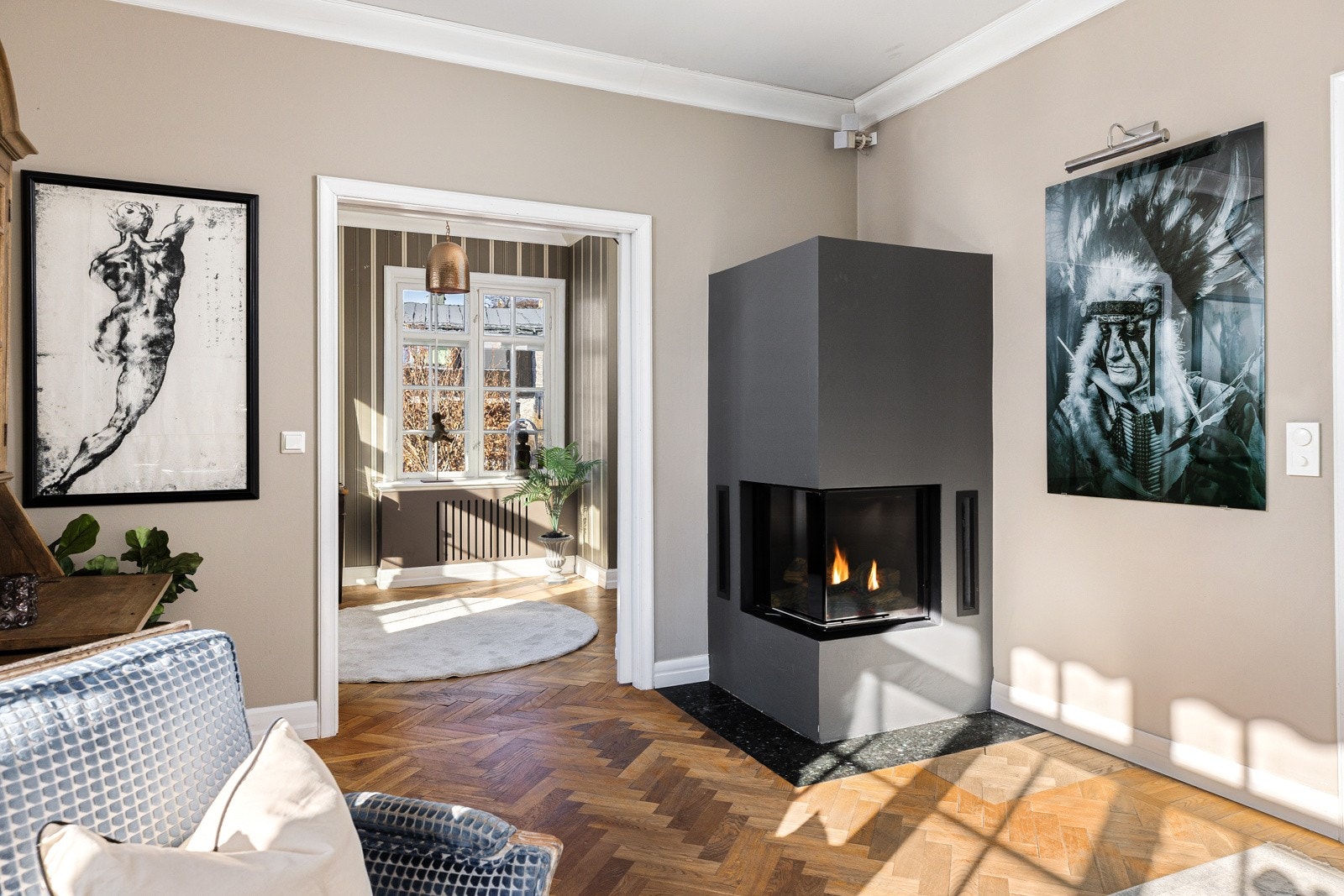 Hovedstuen får hygge fra en stilren hjørnepeis med glass på to sider. Galleribilde