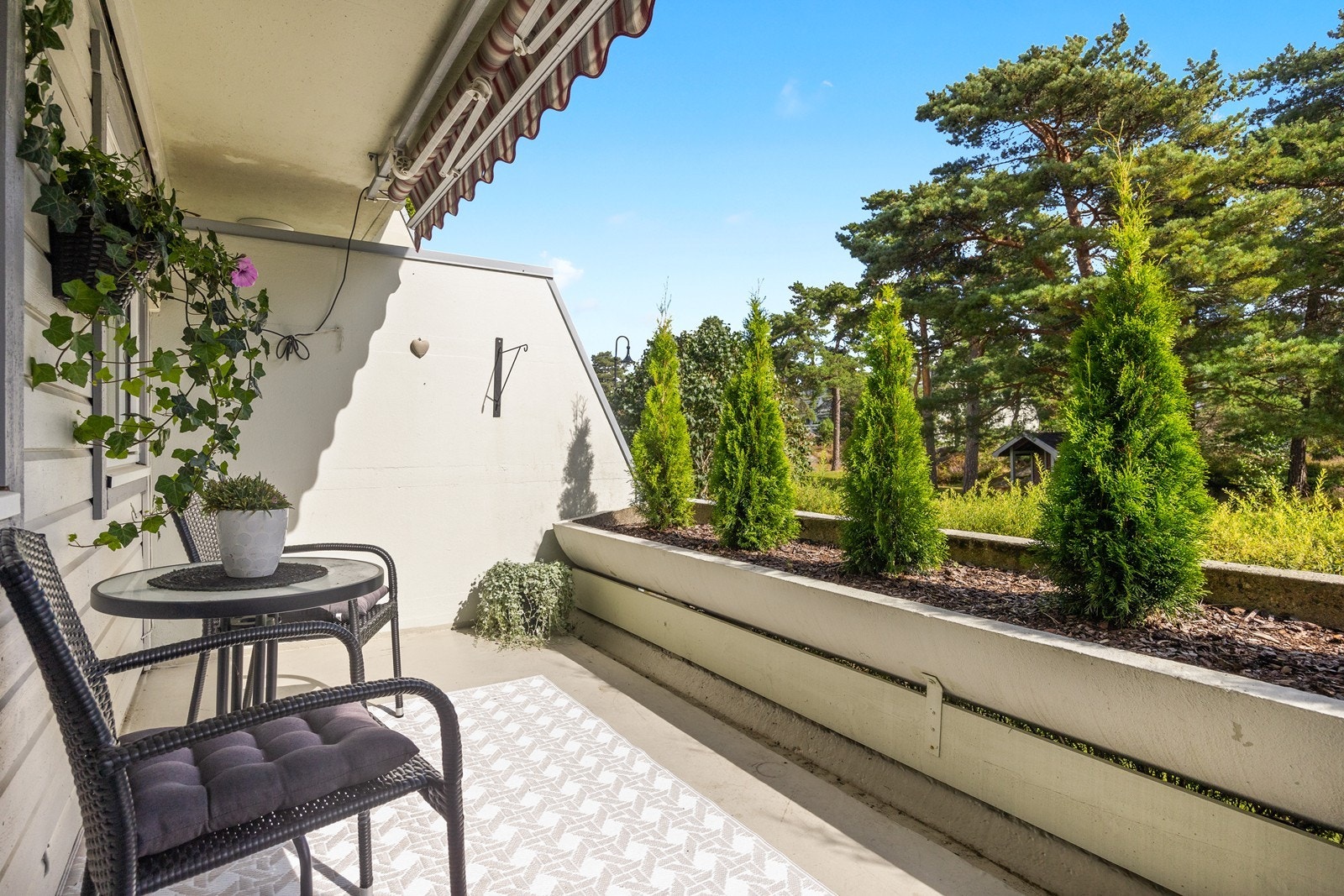 Den koselige verandaen med utgang fra kjøkkenet har også plass til en mindre utegruppe, dessuten er det også montert terrassemarkise her Galleribilde