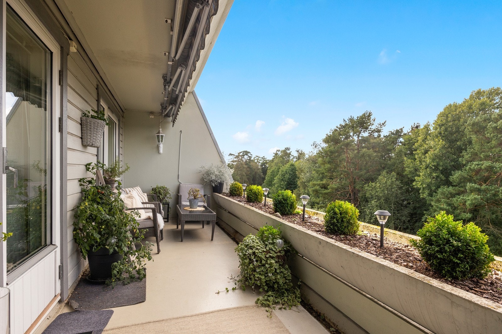 Som rekkverk er det store verandakasser for beplantning. Her er det også satt ned dekorative lamper Galleribilde