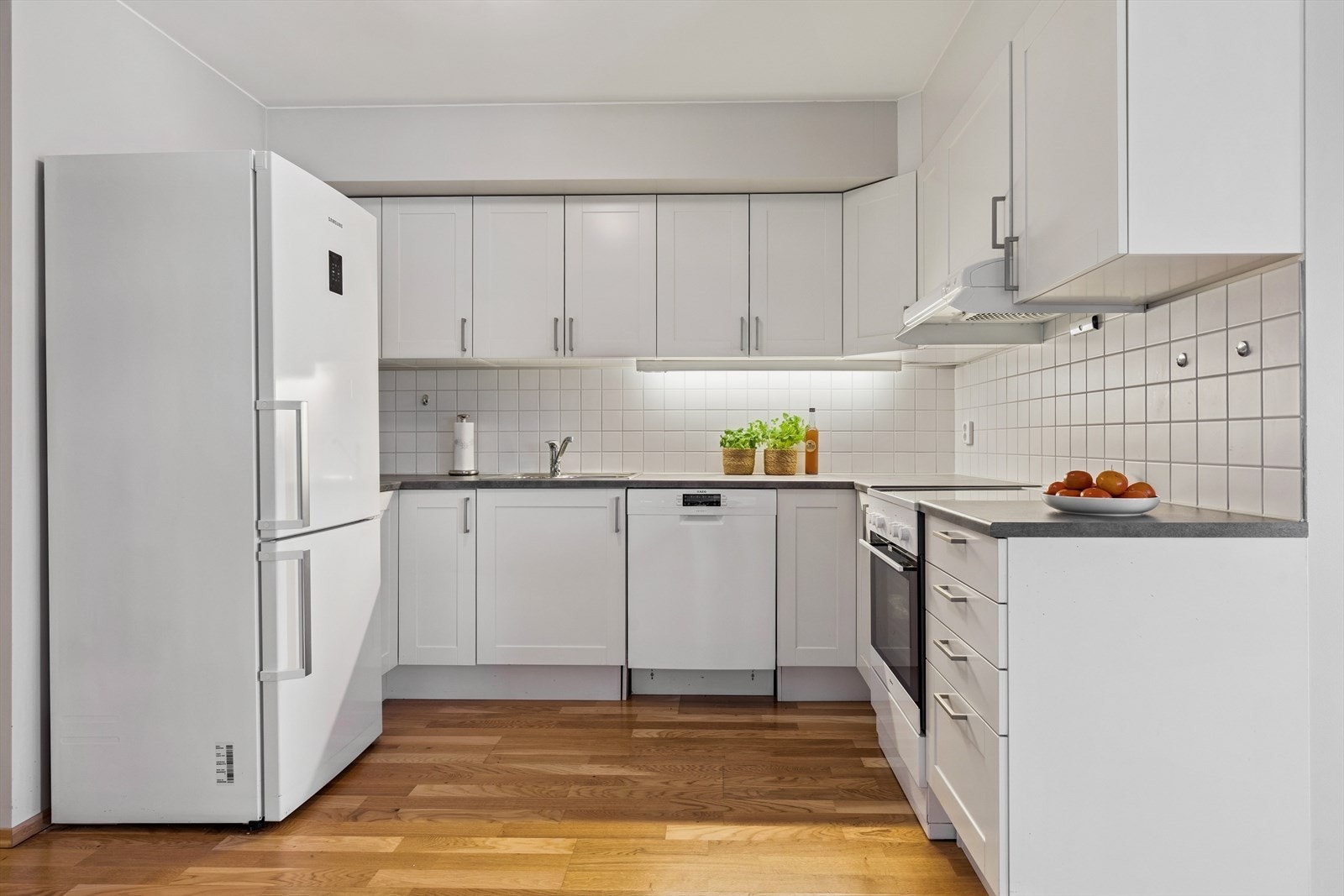 Kjøkkeninnredningen er utstyrt med innebygget oppvaskmaskin, komfyrvakt og fliser over benkeplaten. Galleribilde