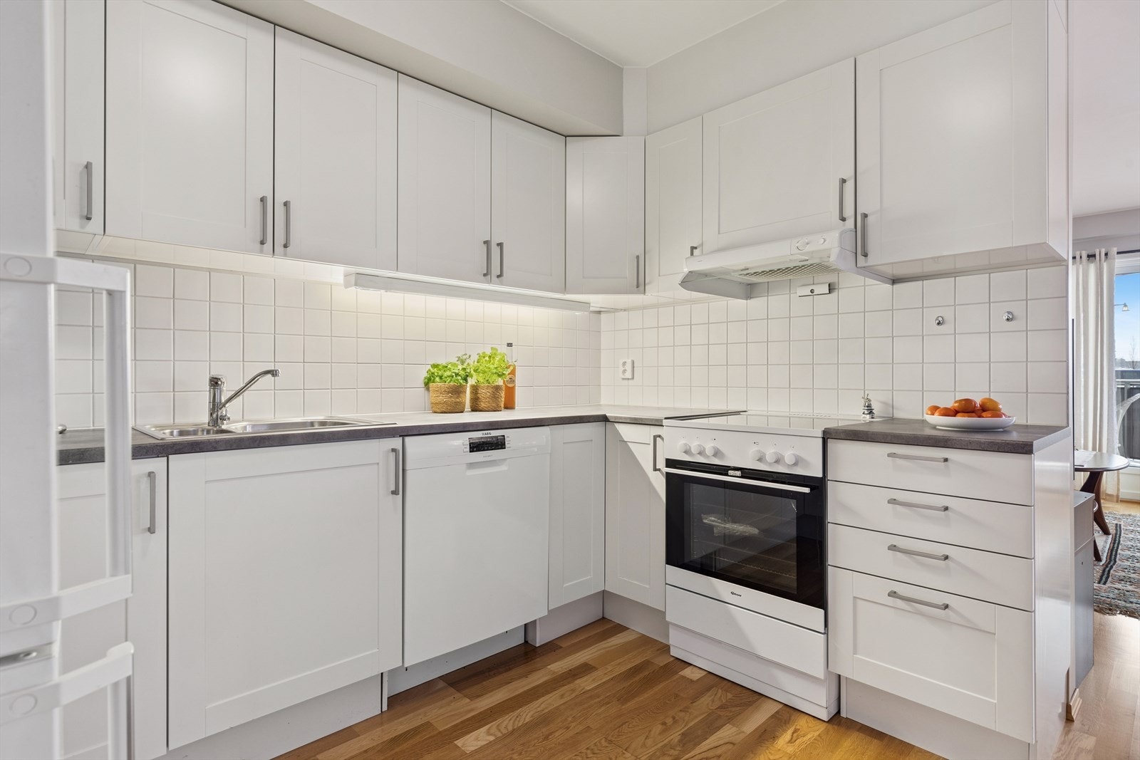 Kjøkkenet har en praktisk, delvis åpen løsning mot stuen, med godt med skap- og benkeplass. Galleribilde