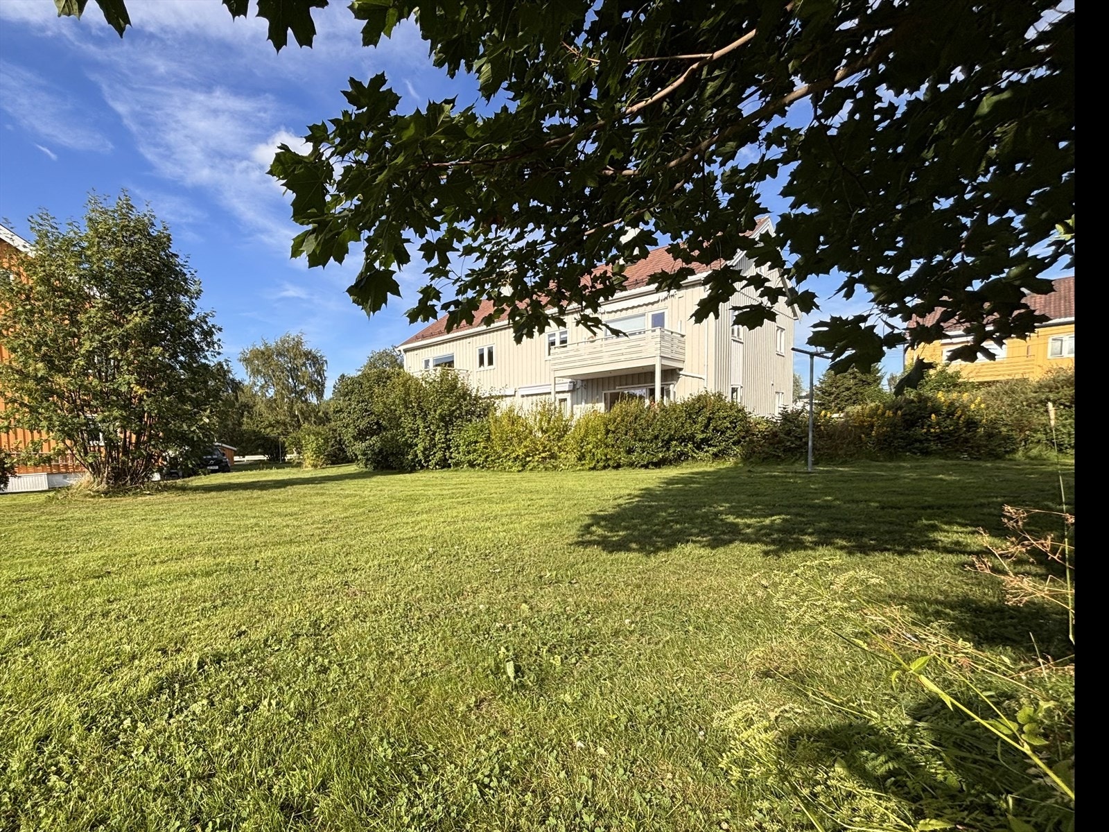 Om sommeren er boligen omkranset av frodige grøntareal med sosiale soner og fantastiske solforhold. (selgers bilde) Galleribilde