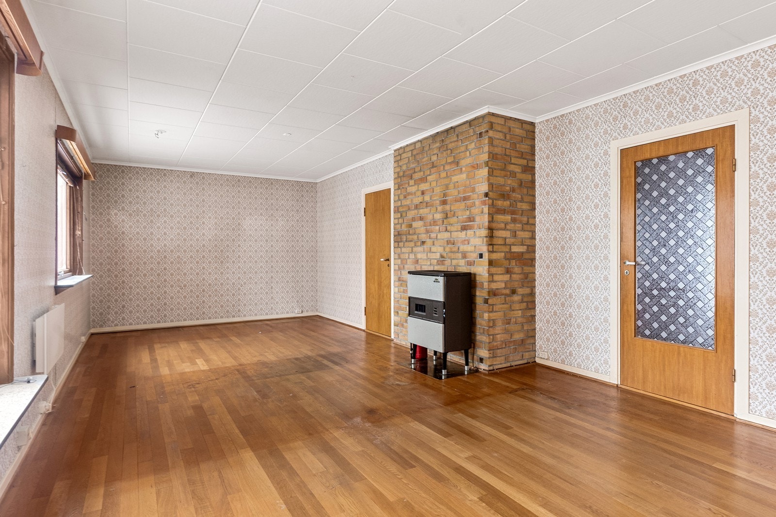 Stuen er romslig og møbleringsvennlig. En eldre parafinovn er installert ved pipen forblendet med teglstein. Denne kan ikke benyttes som oppvarming før den evt. blir konvertert til bruk av biobrensel. Galleribilde