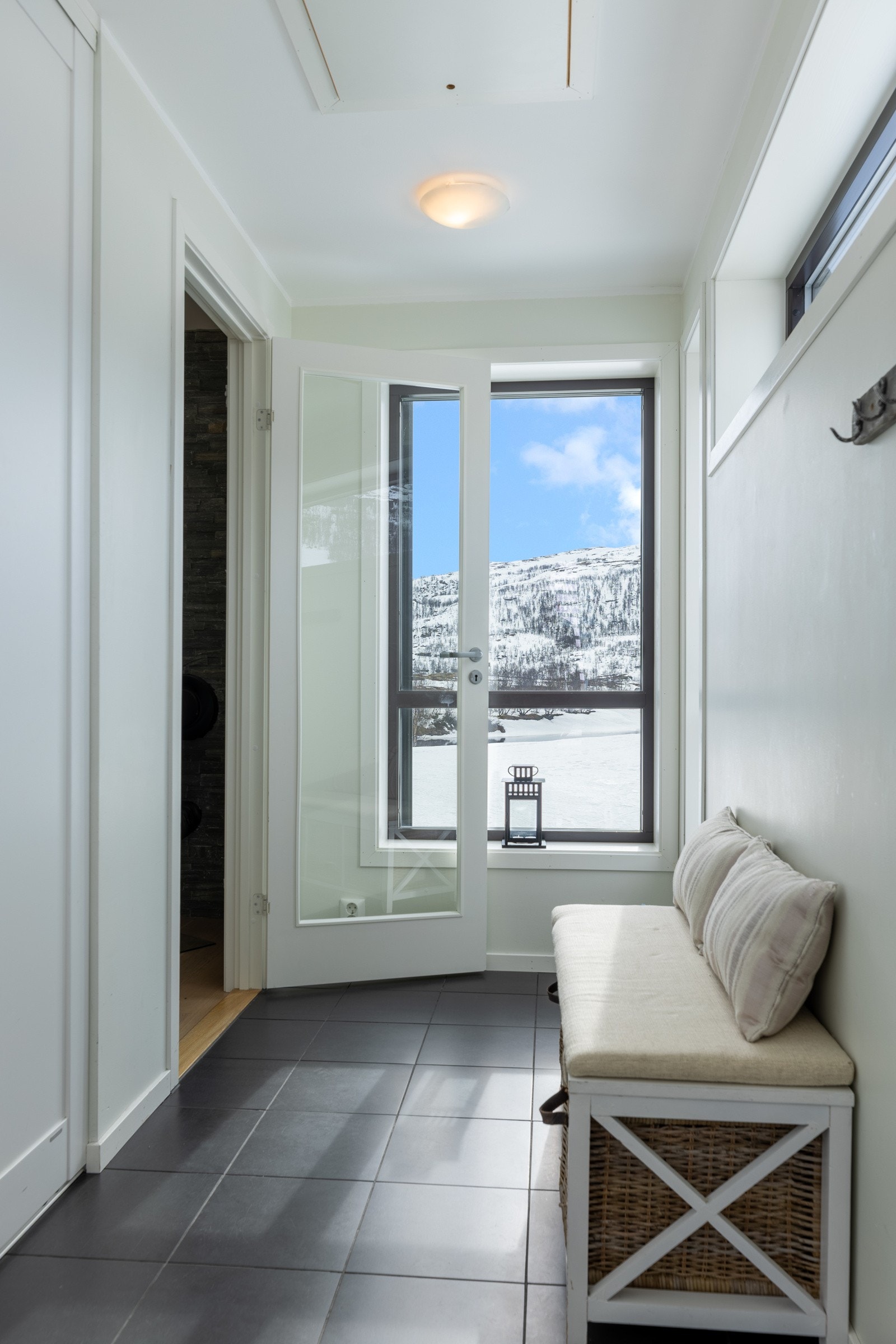 Entré med fliser på gulv m/varmekabler. Lysmalte gipsvegger og garderobeskap. Galleribilde