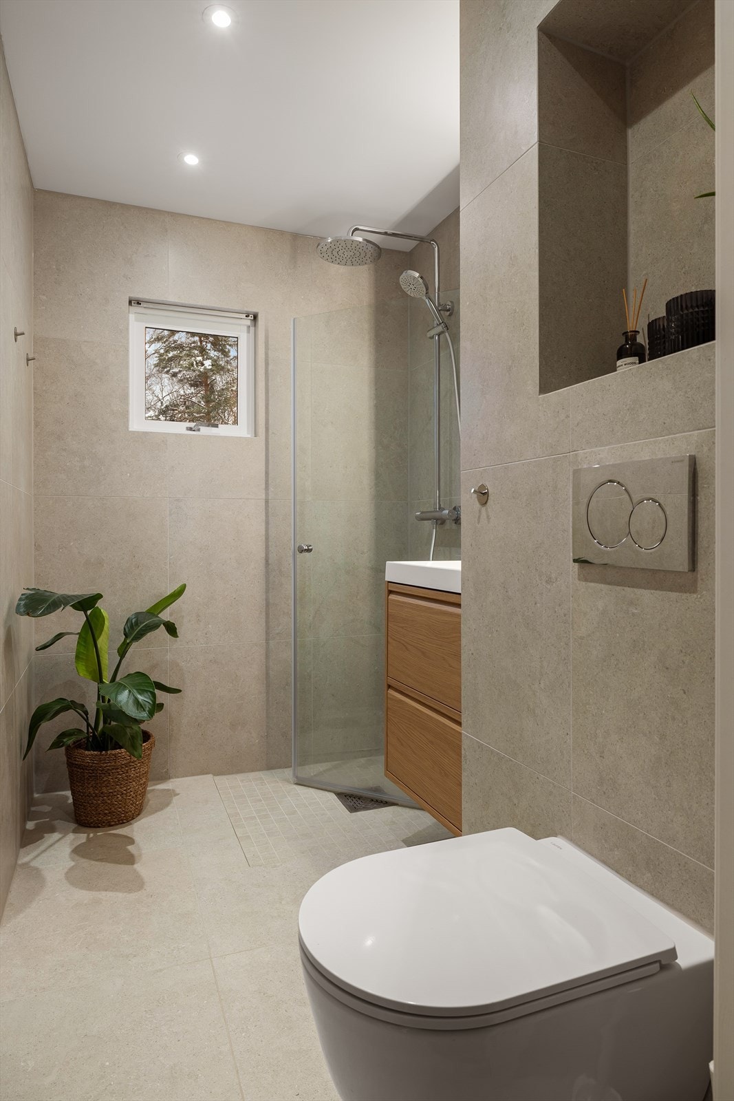 Baderommet har innredning med nedfelt servant, veggmontert toalett og dusjvegger/hjørne. Galleribilde