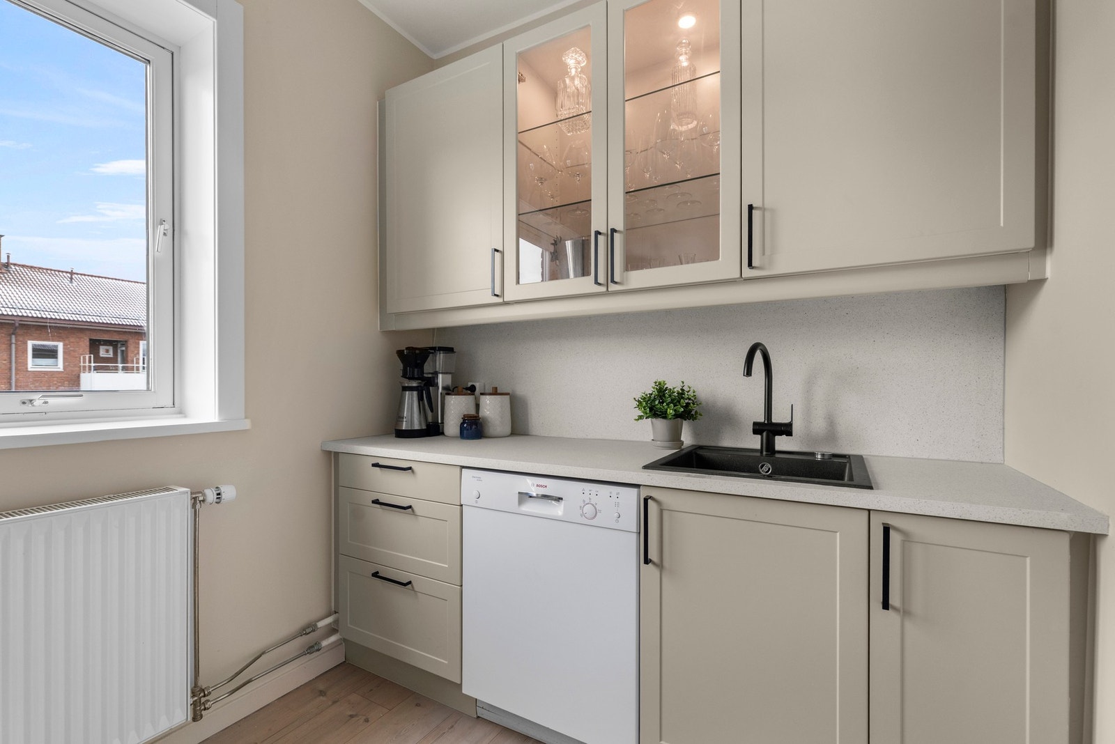 Over vasken er det vitrinedører med innlagt belysning, samt sort armatur og nedfelt kum i kompositt. Galleribilde