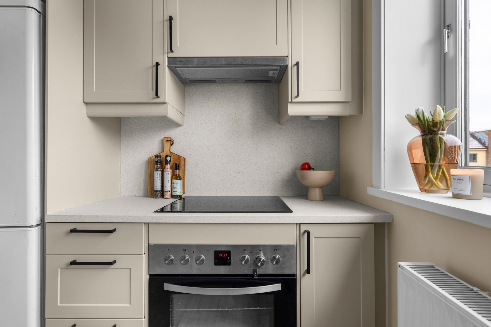 Kjøkkeninnredning med glatte, grå fronter og sorte detaljer som gir et stilrent og harmonisk uttrykk. Galleribilde