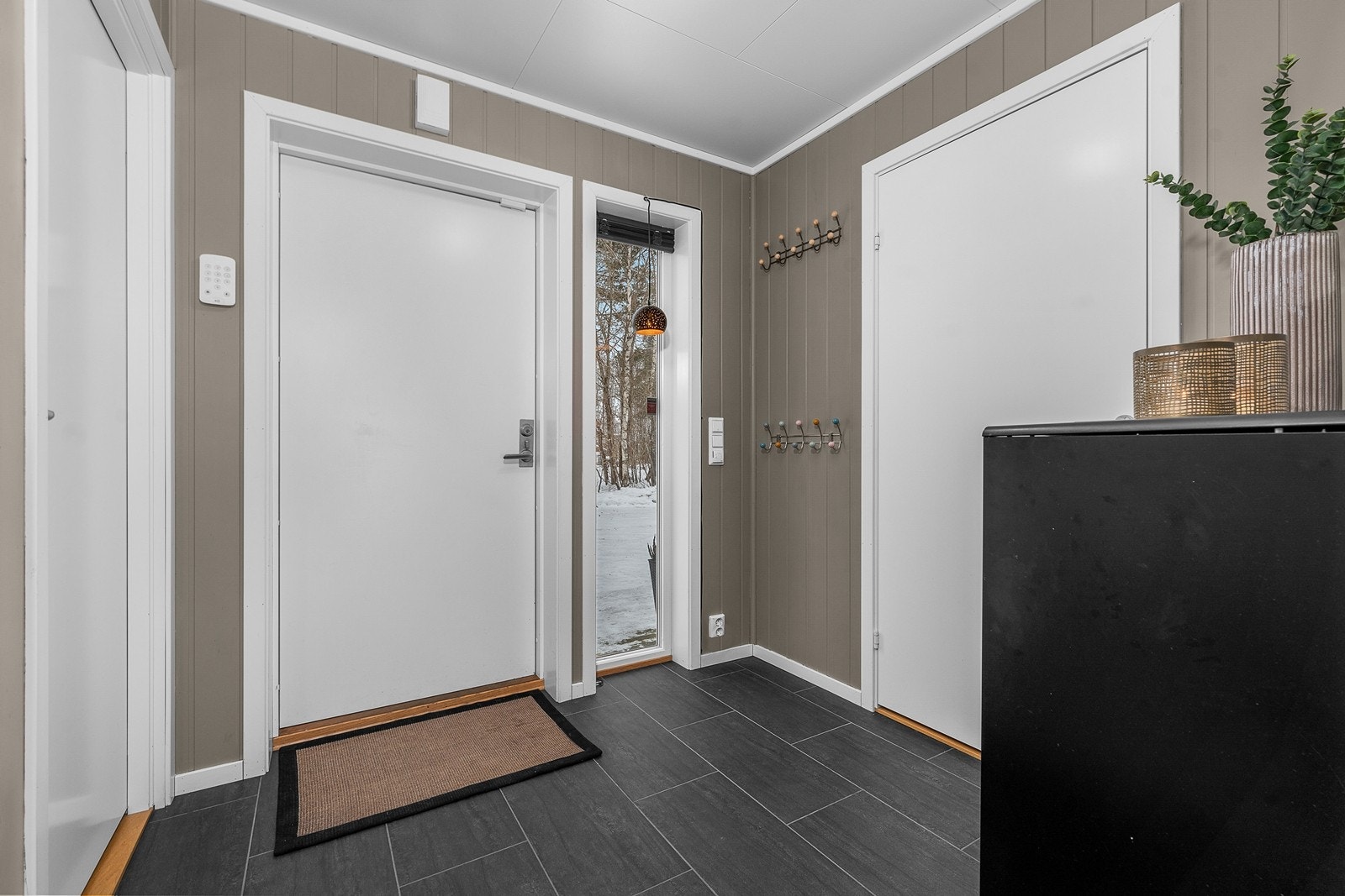 En hyggelig entré ønsker deg velkommen. Entreen har fliser med varme i gulv. Vaskerom ligger praktisk plassert ved inngangsparti, samt bod/teknisk rom for ekstra lagringsplass. Galleribilde