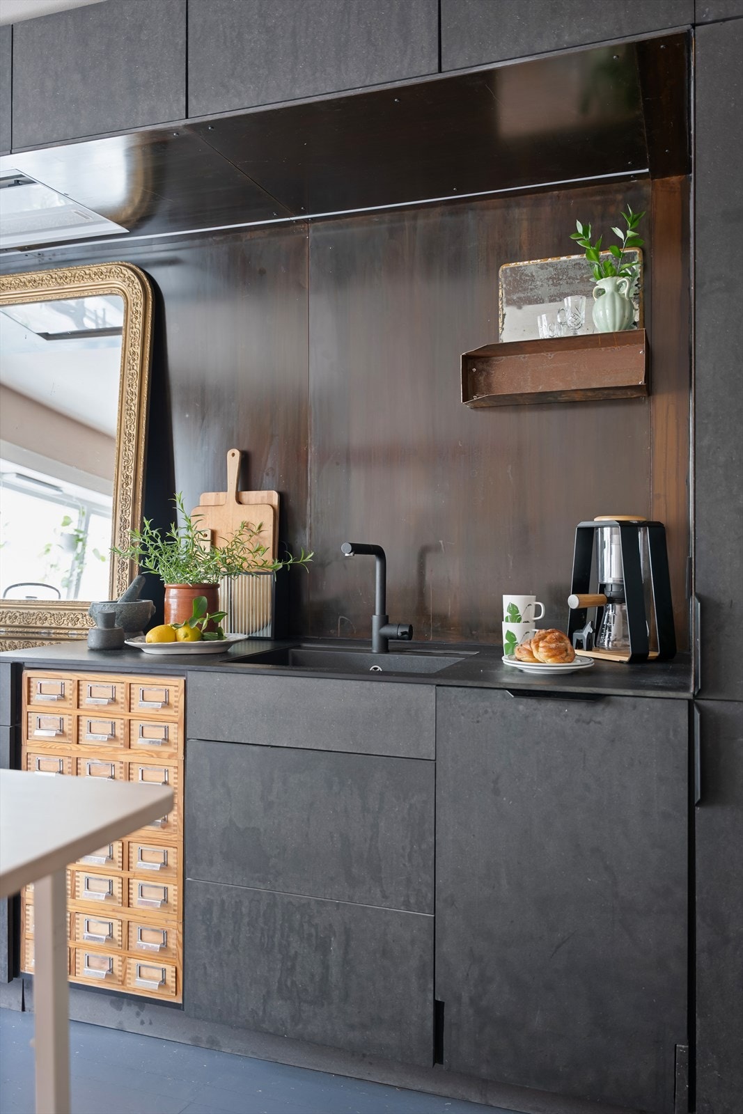 Bakveggen er kledd med lakkerte metallplater, og den underlimte oppvaskkummen bidrar til et stilrent inntrykk. Galleribilde