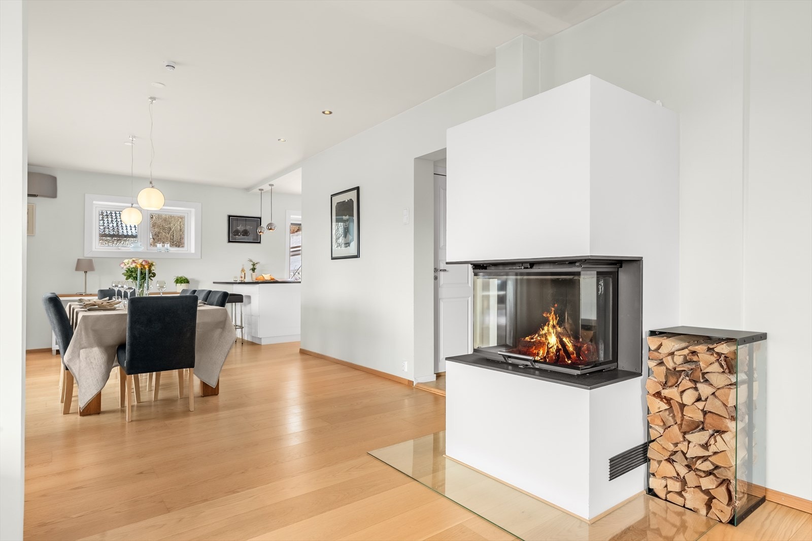 Peisen lager et naturlig skille mellom sofakroken og spisestuen Galleribilde