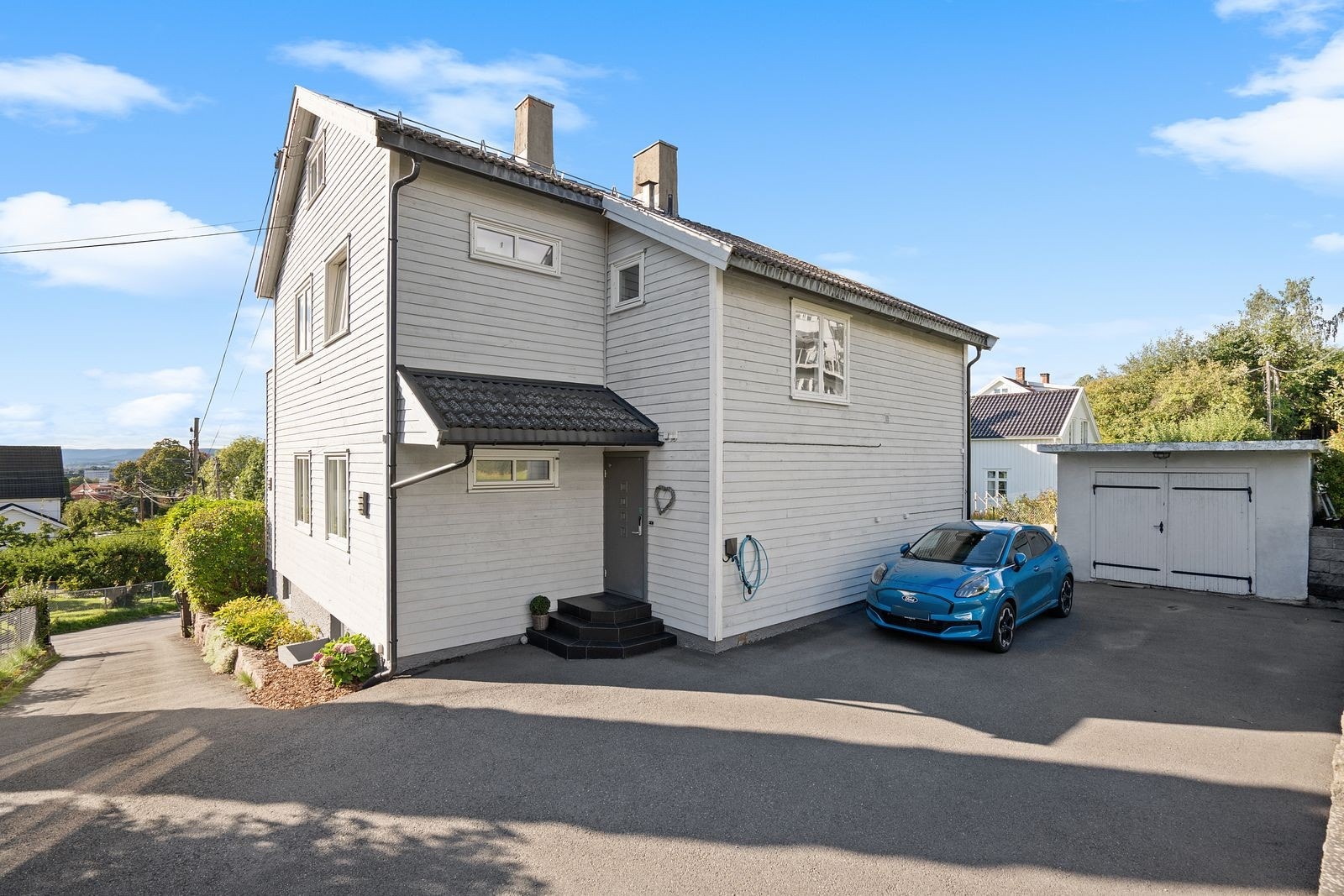 Gårdsplassen er pent opparbeidet med asfalt og støttemur - i oppkjørselen er det varmekabler Galleribilde