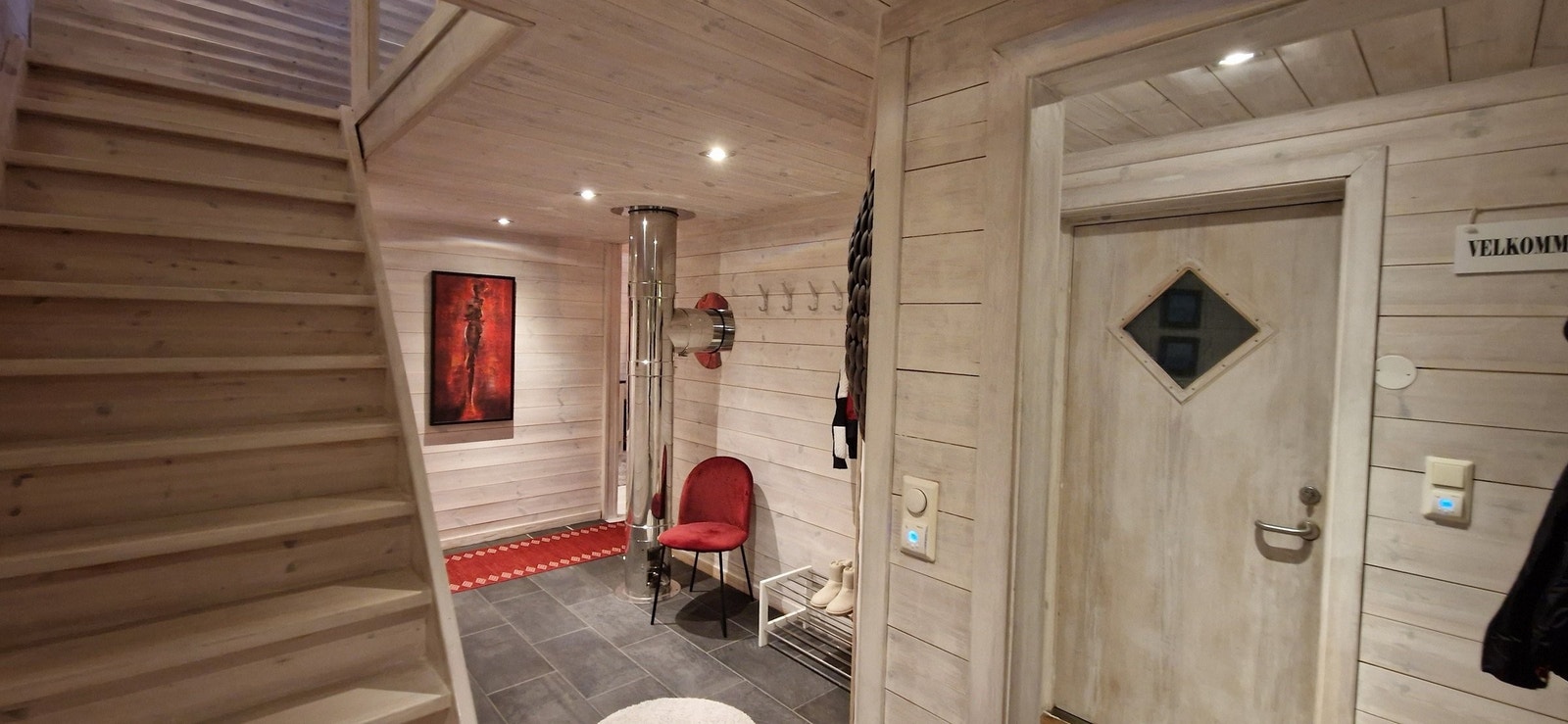 Inngang med vindfang hvor man kan henge fra seg yttertøy. Deretter kommer man inn i gangen. Galleribilde