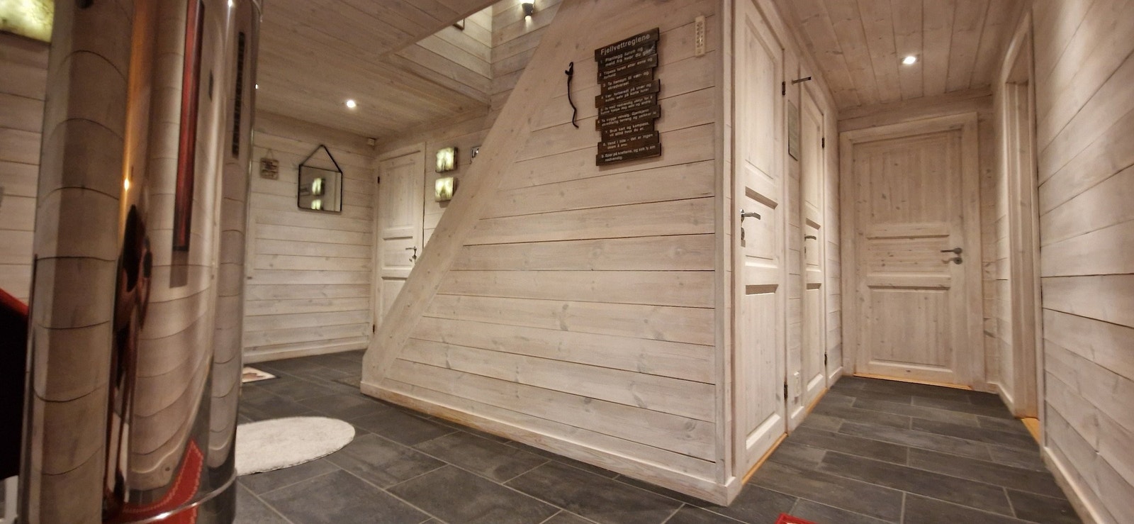 Romslig gang med skifergulv med varmekabler. Fra gangen har du tilgang til vaskerom/bod/vedbod, gjestetoalett, bad/badstue, hovedsoverom og soverom. Galleribilde