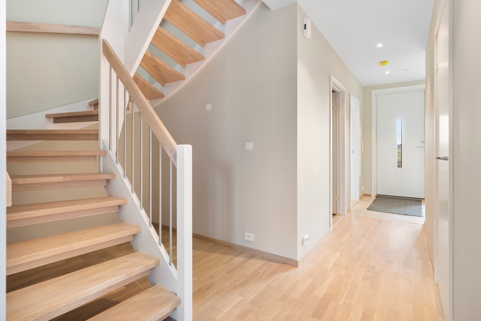 Innbydende inngangsparti med parkett og fliser, lysmalte veggflater og varmekabler i deler av gulvet. Galleribilde