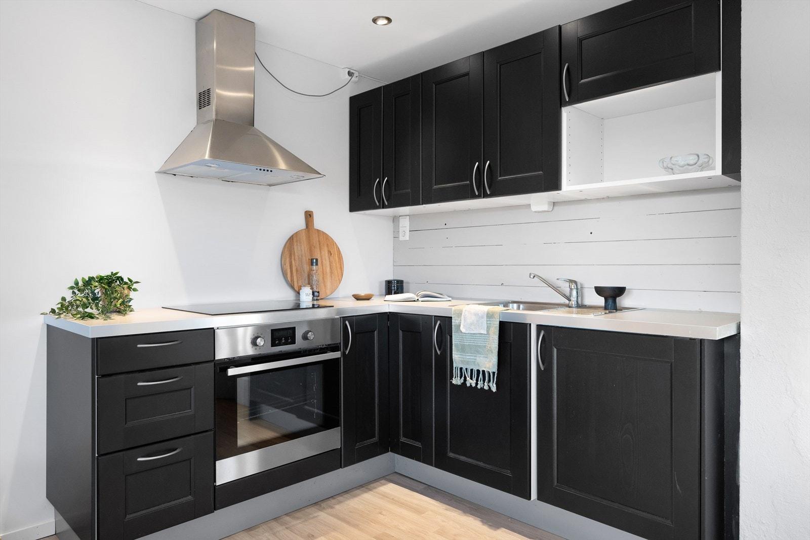 Kjøkkenet her har moderne mørke profilerte fronter og integrert stekeovn og platetopp. Galleribilde