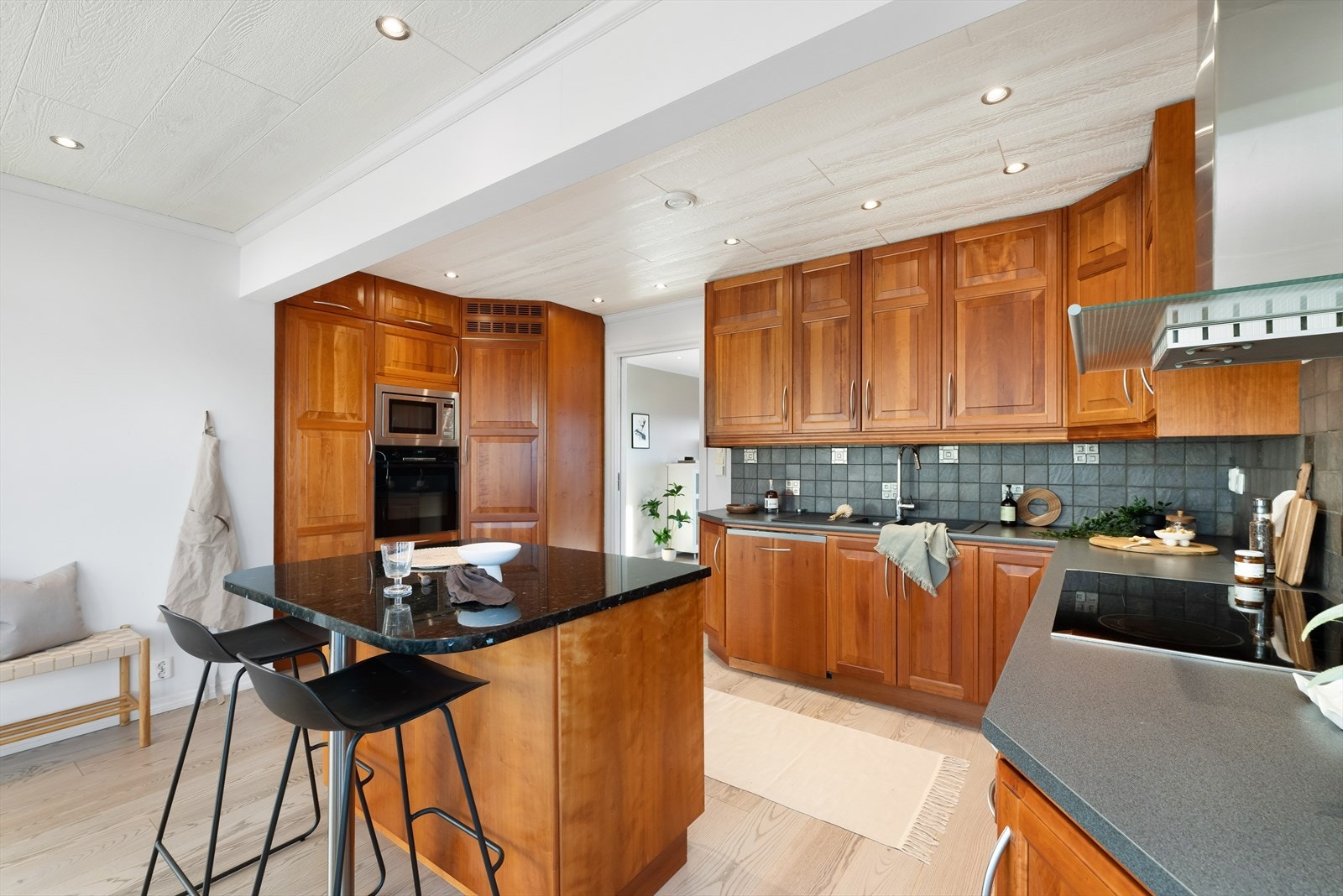 Flott kirsebærtre farget kjøkkeninnredning med profilerte fronter og rikelig med oppbevaringsplass. Galleribilde