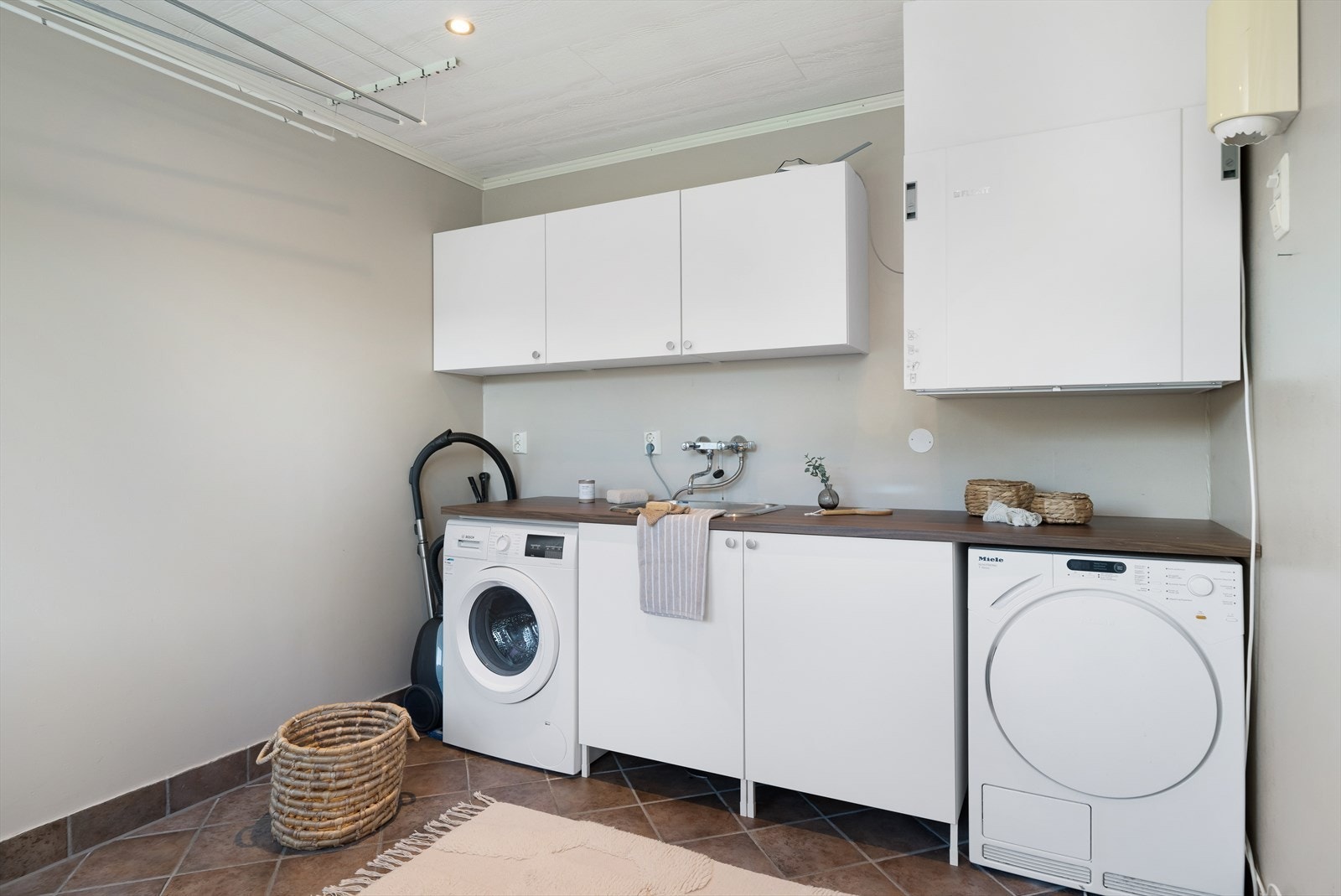 Fra kjøkkenet har man tilgang til romslig vaskerom med opplegg for vaskemaskin, utslagsvask og brettebenk. God plass for klestørk til den aktive familien. Galleribilde
