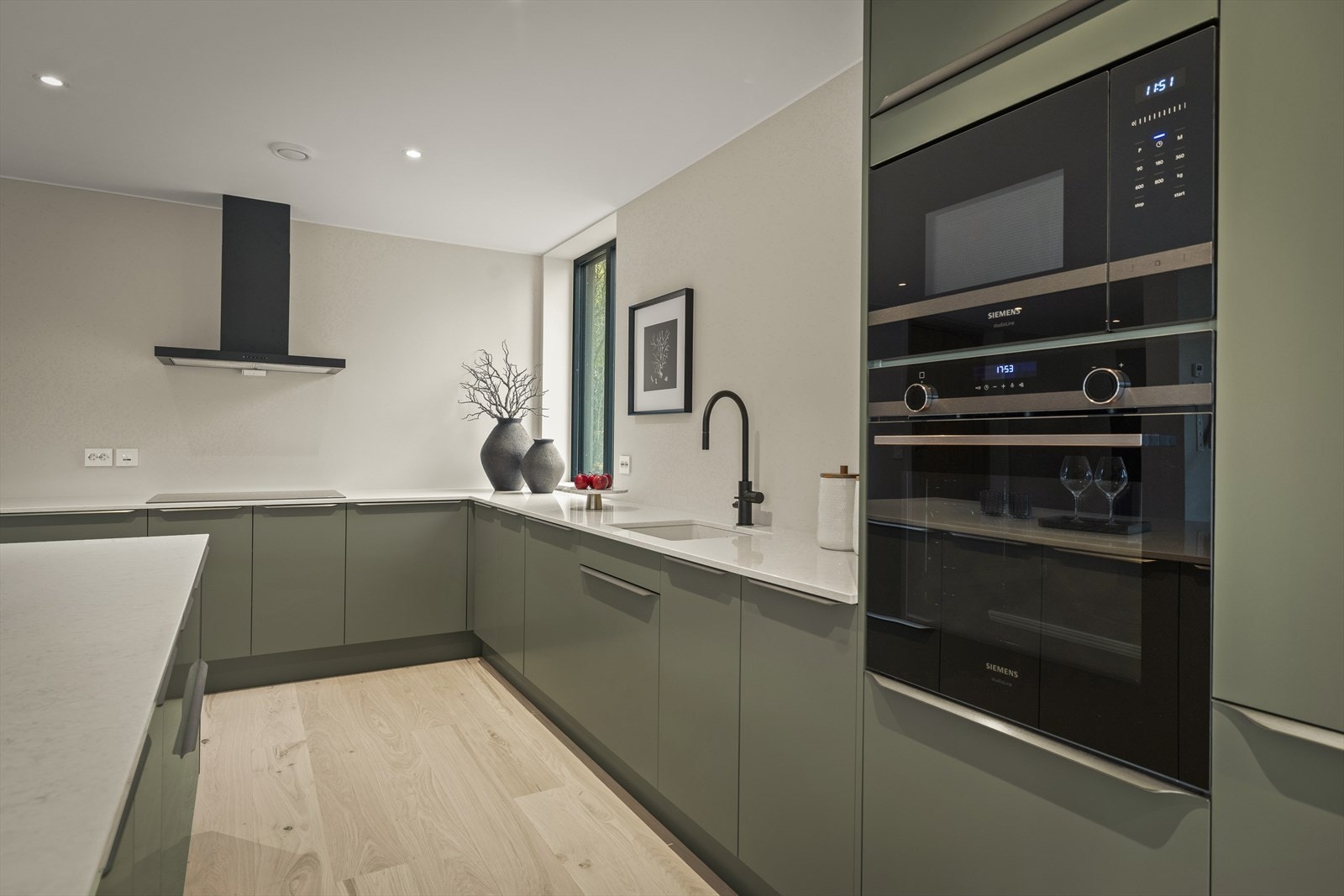 Kjøkkenet har slette og renholdsvennlige fronter i en tidsriktig farge og har hvitevarer fra Siemens Galleribilde