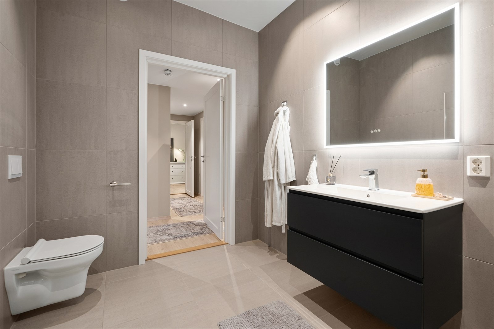 Baderommet har vegghengt toalett og servant med skuffer. Galleribilde