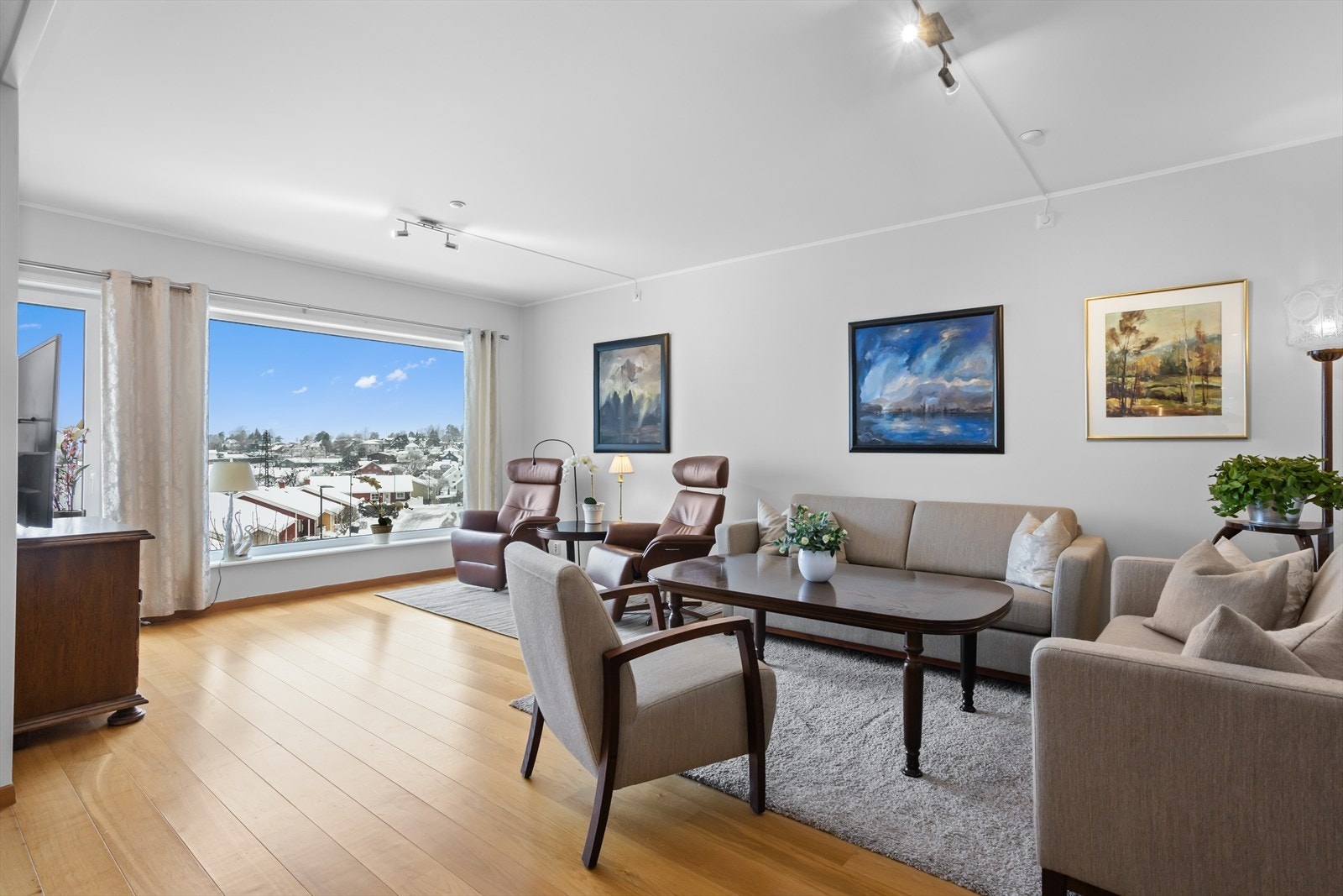 Stuen og spisestuen ligger i åpen løsning mot kjøkkenet, og rommet særpreges spesielt av de store og dype glassflatene. Det er godt med veggplass å møblere mot, og verandadøren mellom stuen og kjøkkenet tar deg ut til terrassearrangementet. Galleribilde