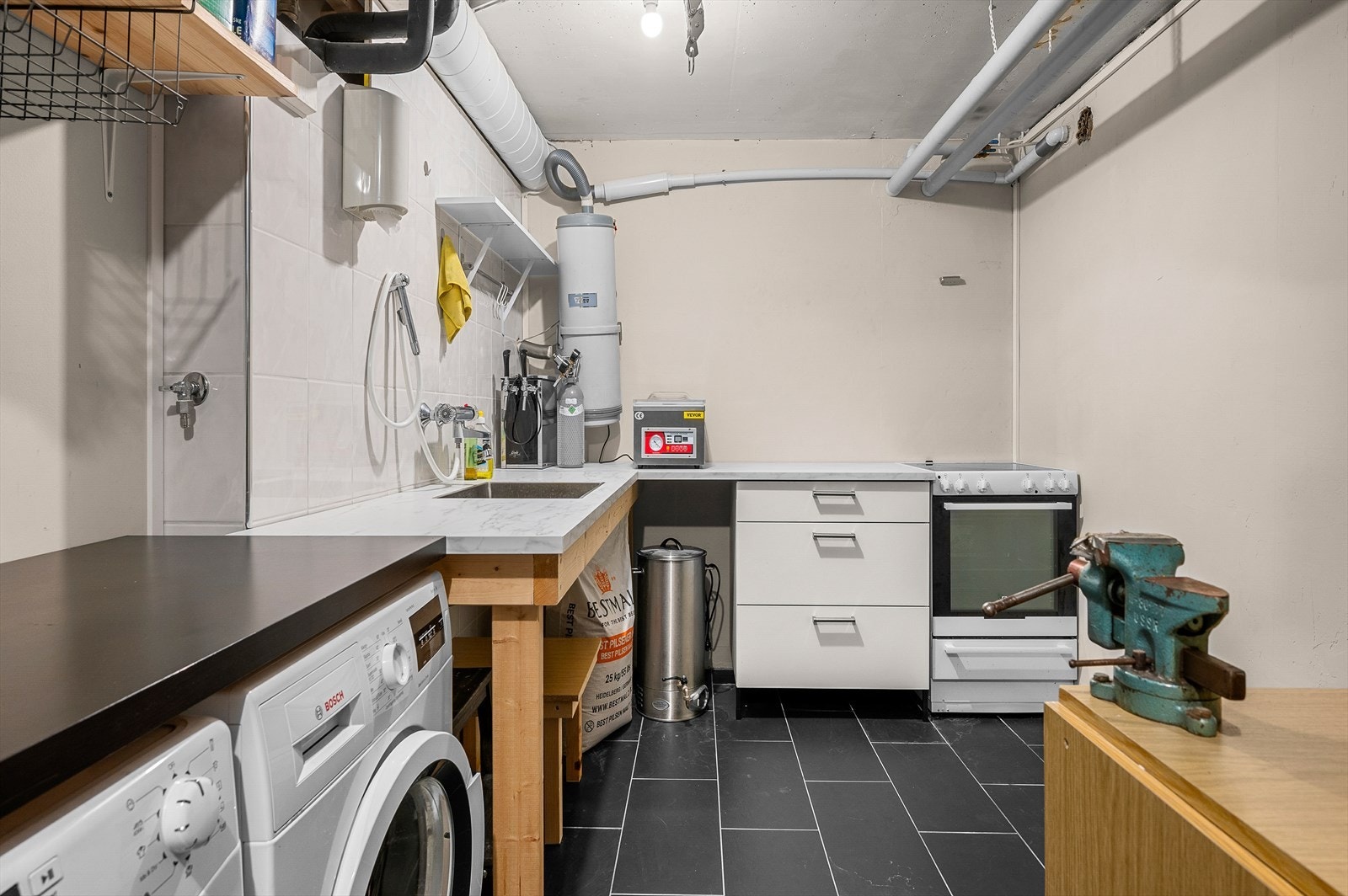 Bod i kjeller har flis på gulv og ble innredet med grovkjøkken og innredning med utslagsvask i 2020 Galleribilde