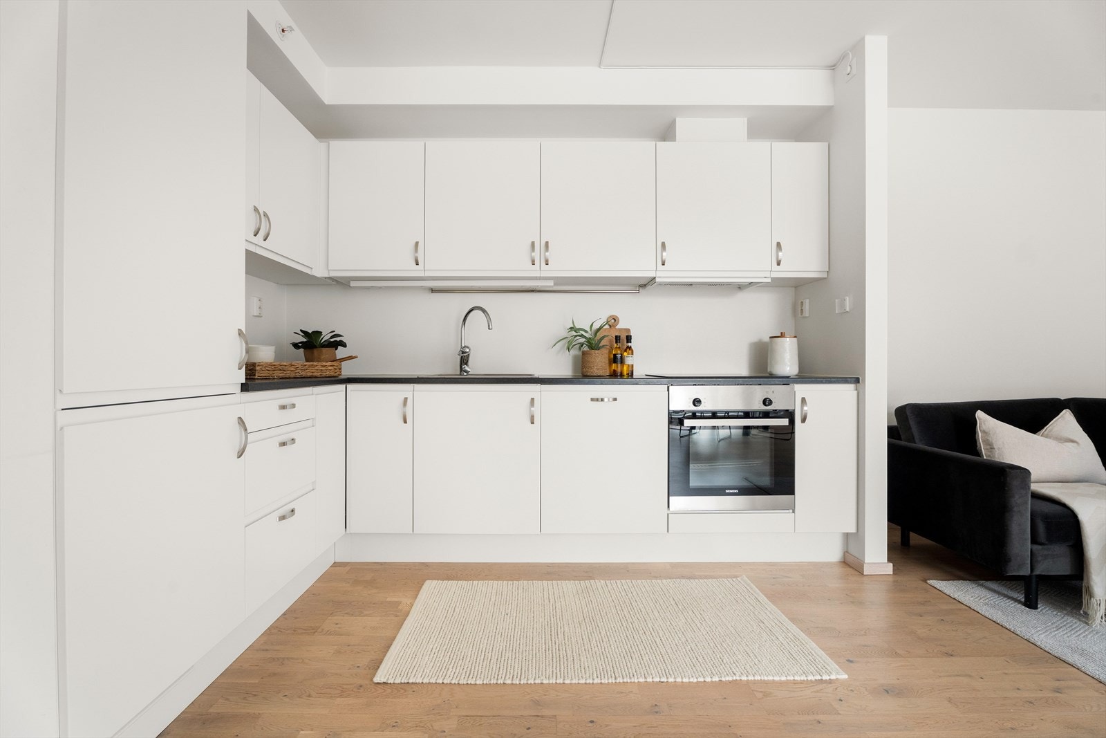 Kjøkkeninnredningen har integrerte hvitevarer som kjøleskap, oppvaskmaskin, platetopp og stekeovn. Galleribilde