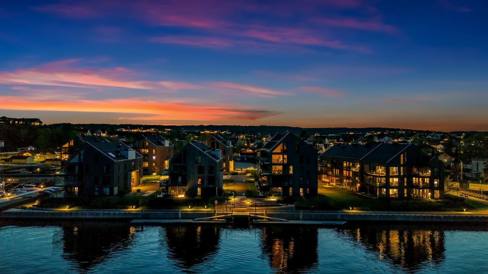 Stemningsfull belysning skaper en lun atmosfære i boligområdet på kveldstid. Galleribilde