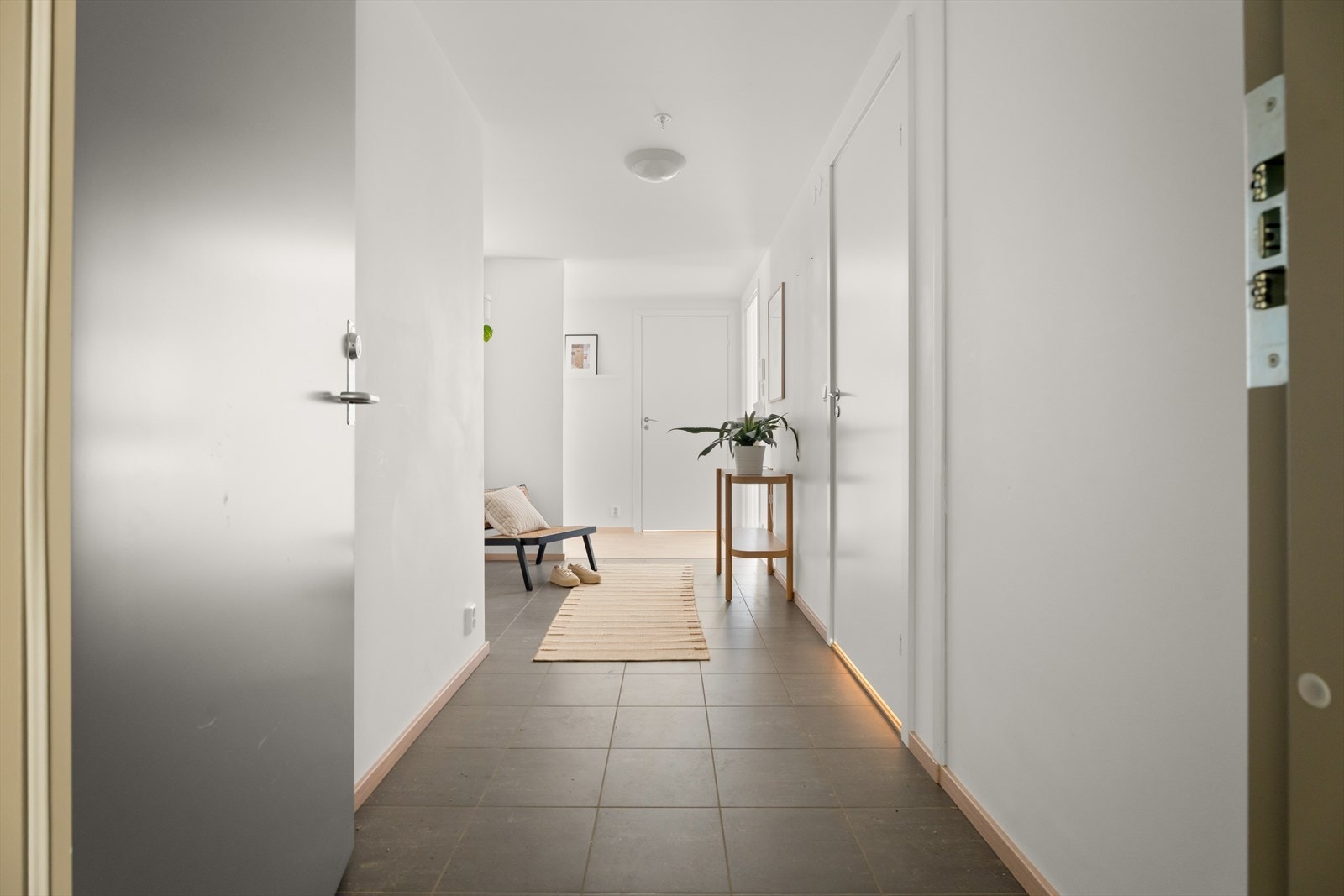 En romslig entré ønsker velkommen inn, med slitesterke keramiske fliser på gulvet. Galleribilde