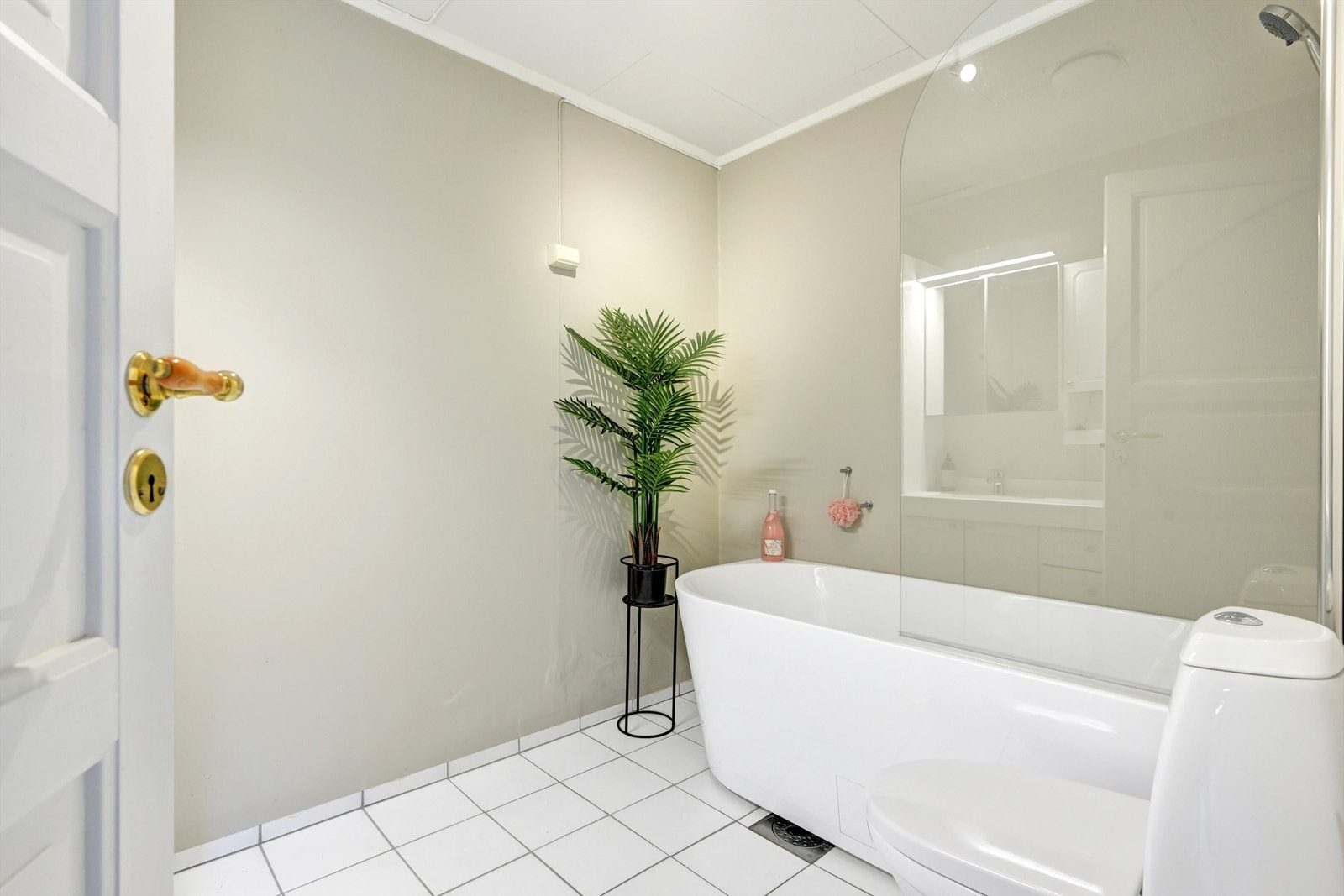 Lekkert baderom med lyst flislagt gulv. Galleribilde