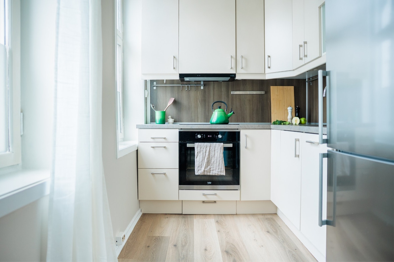 Lyst og tidløst kjøkken fra 2017 med integrerte hvitevarer. Galleribilde