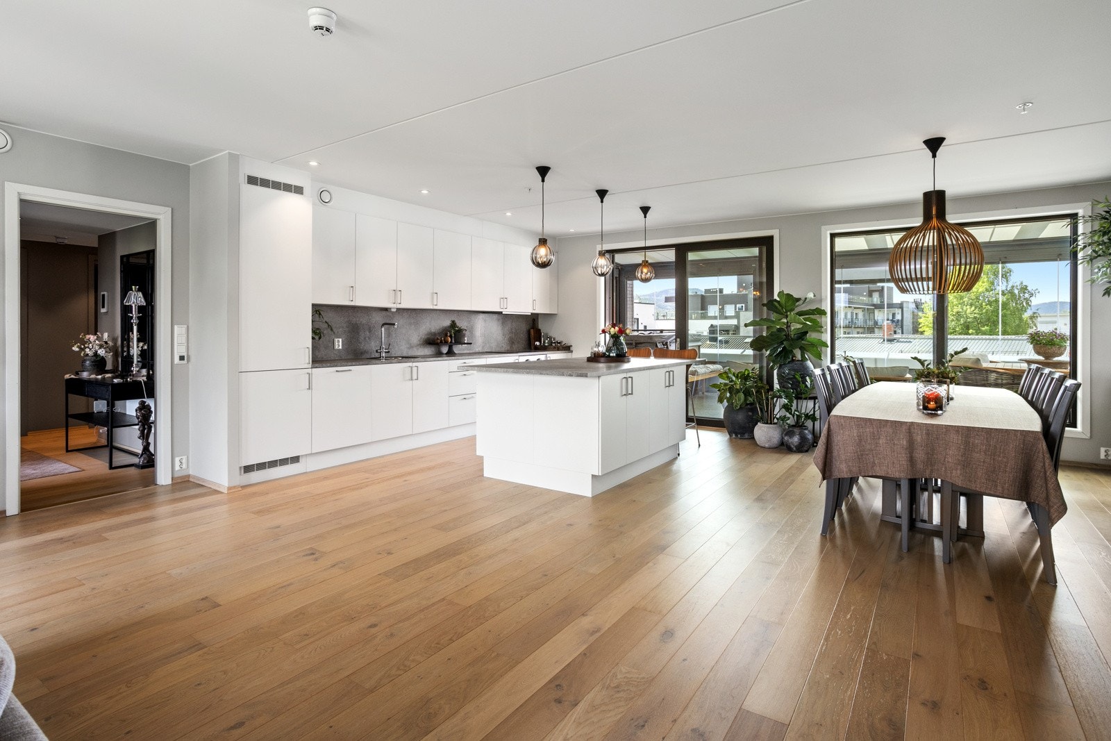 Stor stue med moderne åpen kjøkkenløsning mot spisestuen Galleribilde