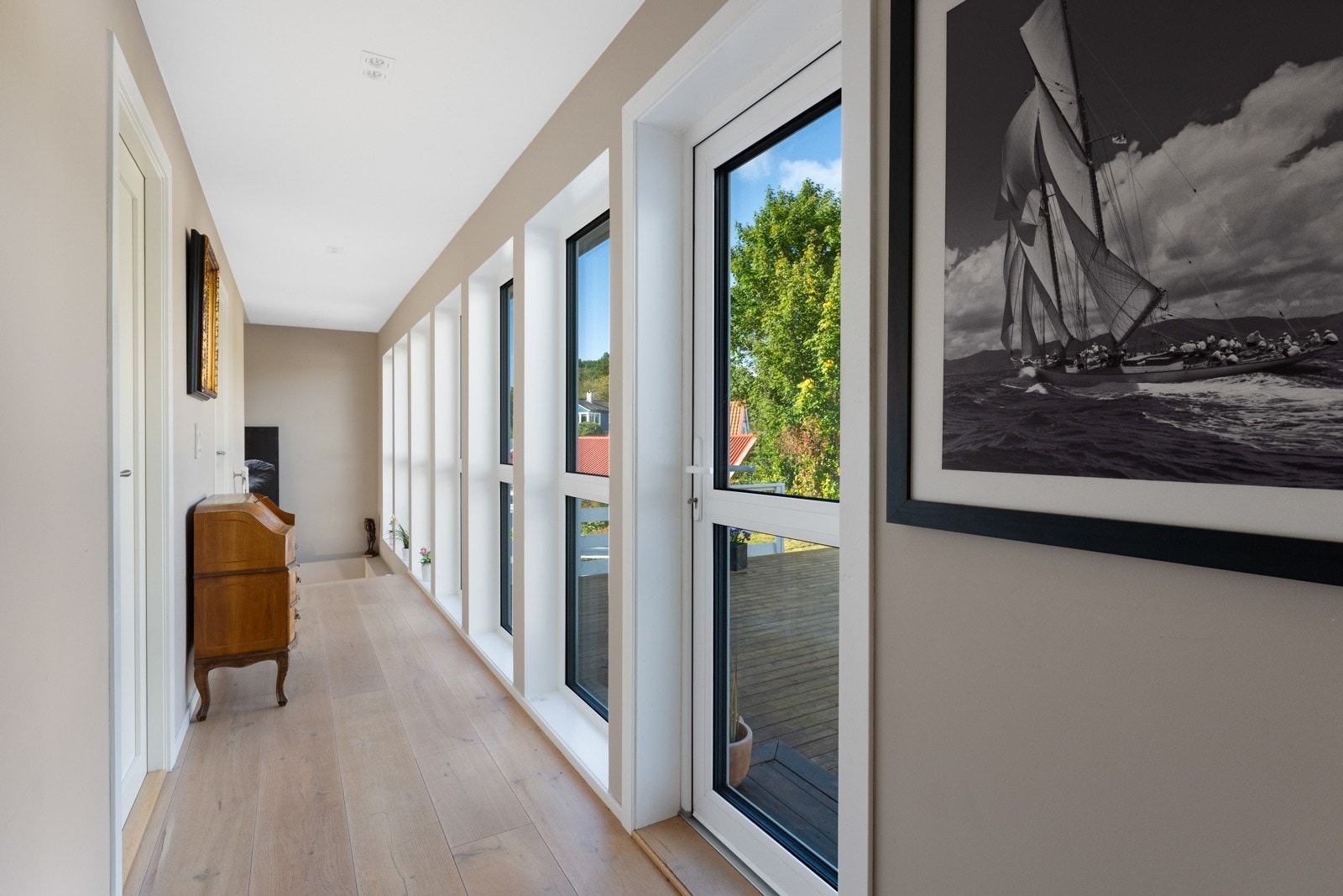 Videre opp i hovedetasjen møtes man av en langstrakt gang med store vindusflater som slipper inn rikelig med naturlig lys. Galleribilde