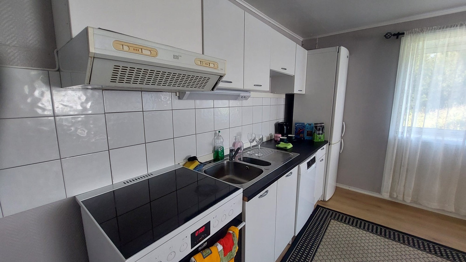 Kjøkken med induksjonsovn, oppvaskmaskin og kjøleskap Galleribilde